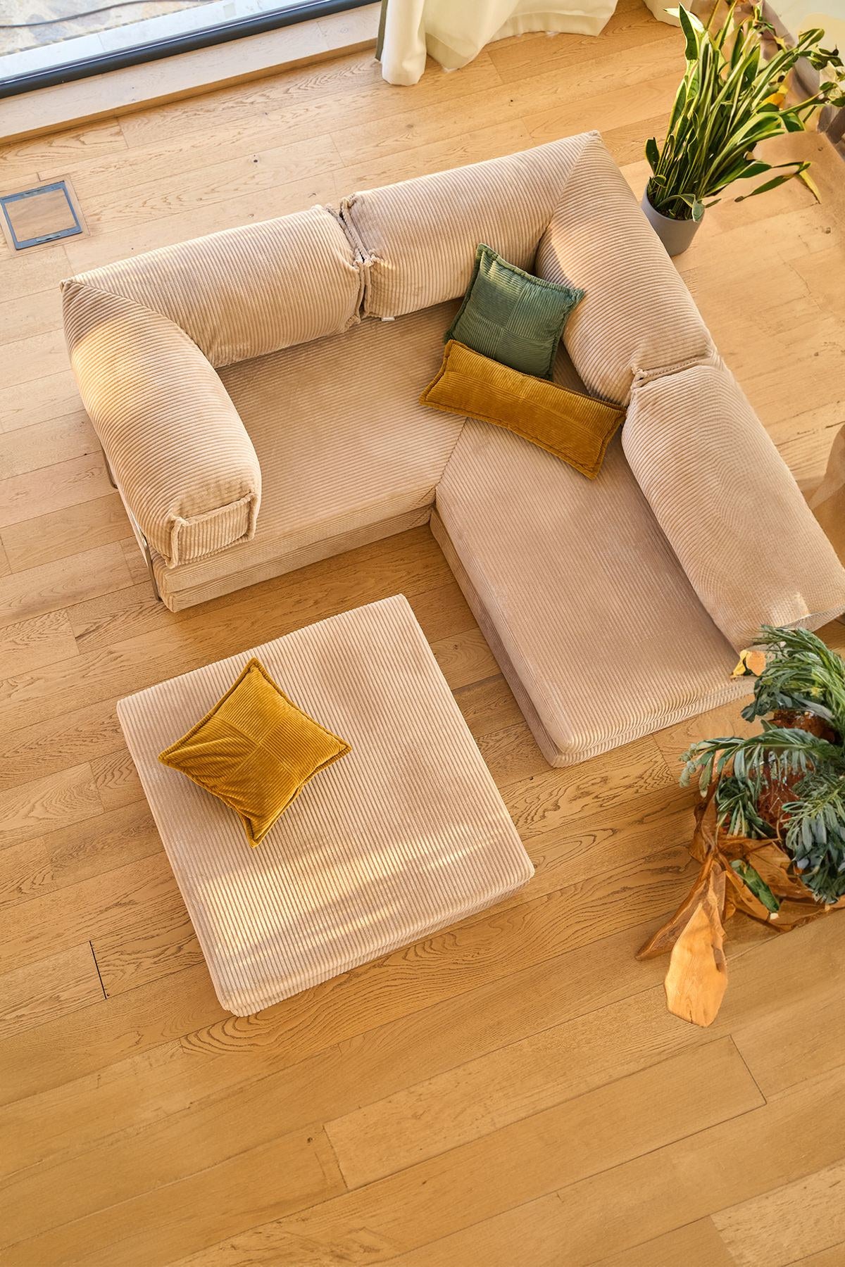 Beiges Eck-Schlafsofa Kanyon von Hanah Home aus geripptem Cord-Plüschstoff, L-Form mit vier Kissen, auf hellem Untergrund fotografiert.