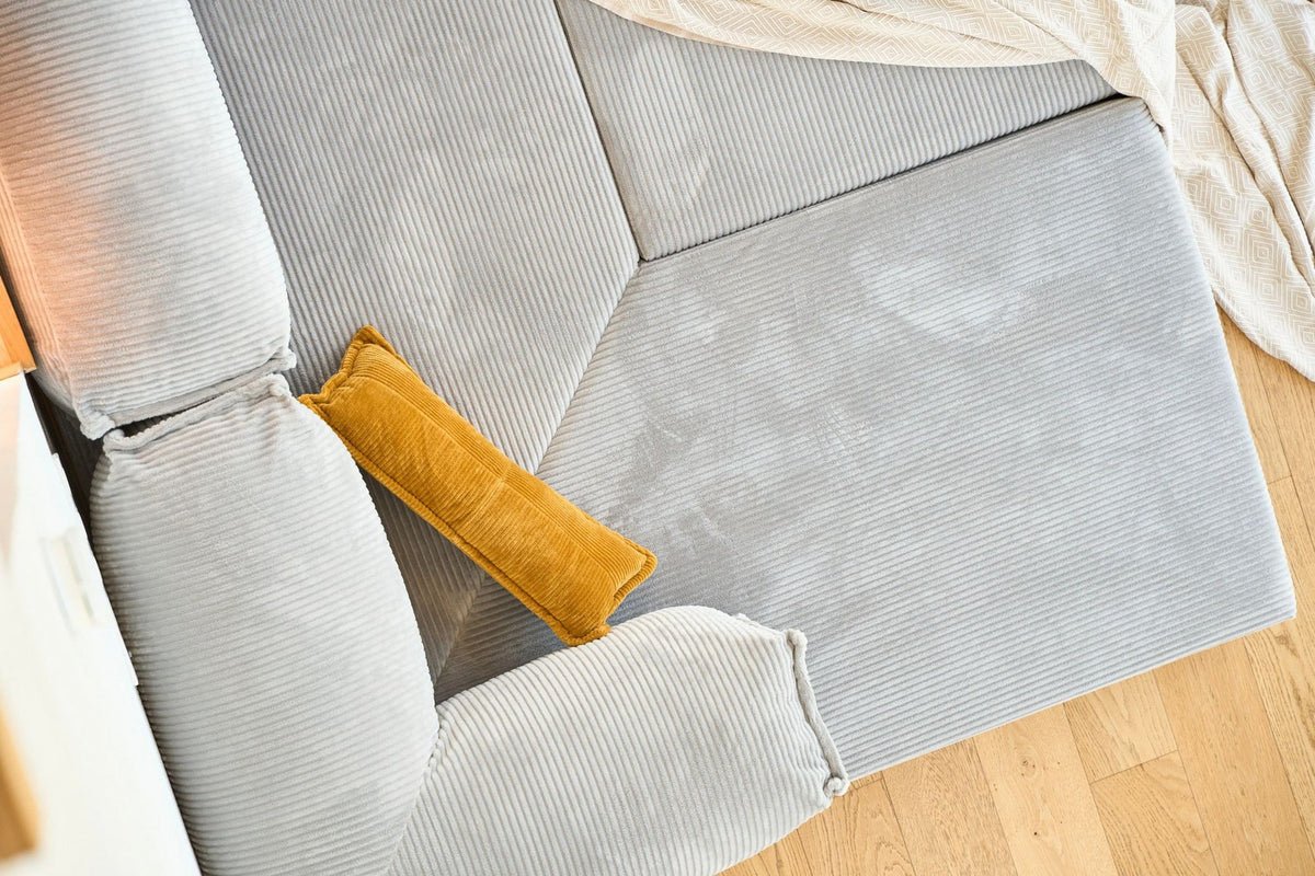 Hellgraues Eck-Schlafsofa Kanyon von Hanah Home aus Cord-Plüschstoff mit vier Kissen, Ecksofa-Form, Sitzhöhe 36 cm.