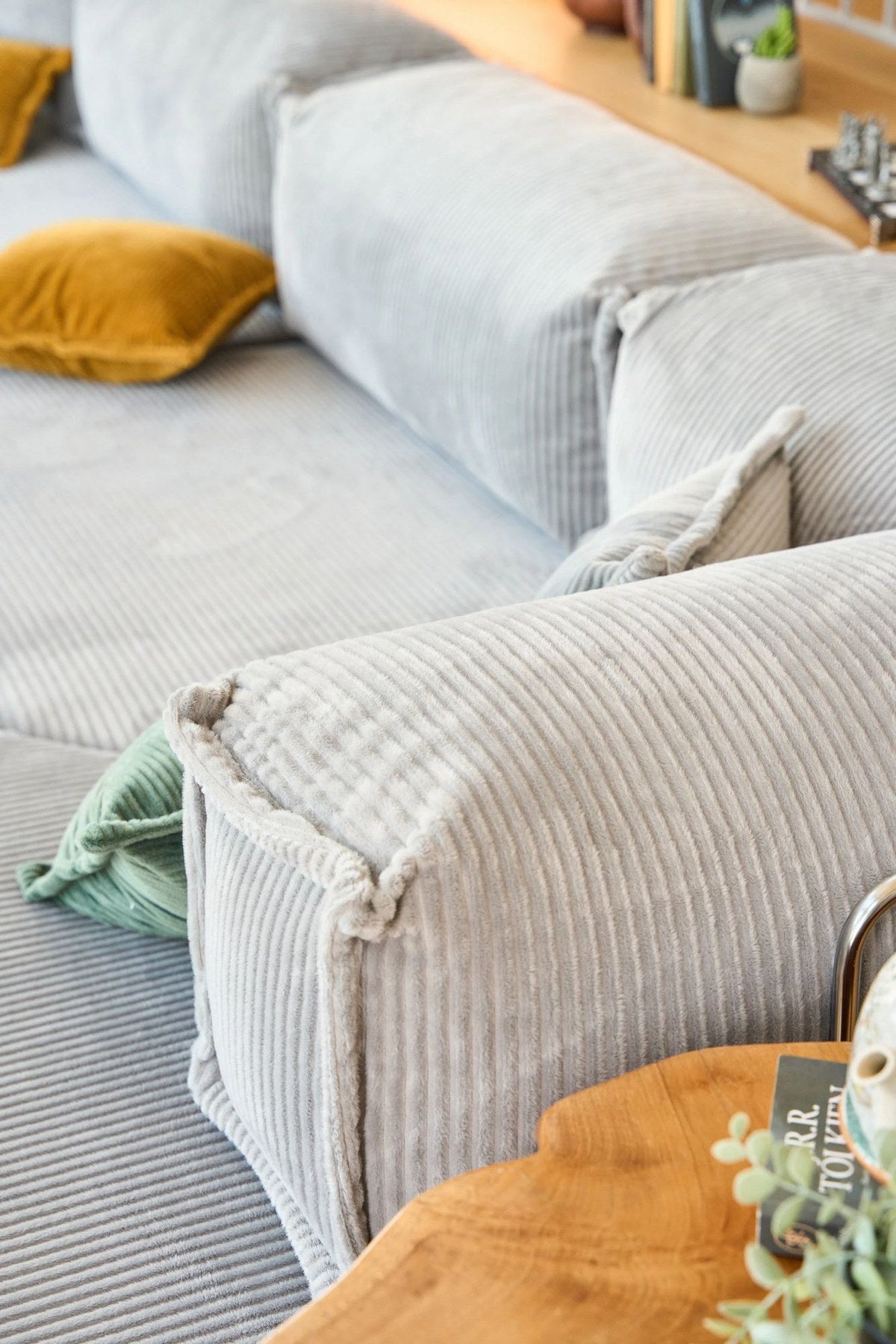 Hellgraues Eck-Schlafsofa Kanyon von Hanah Home aus Cord-Plüschstoff mit vier Kissen, Ecksofa-Form, Sitzhöhe 36 cm.