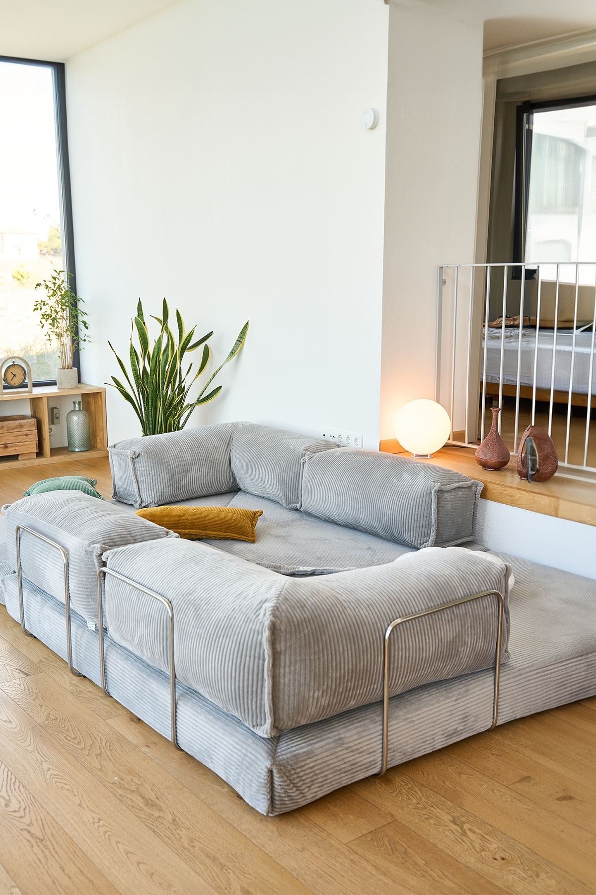 Hellgraues Eck-Schlafsofa Kanyon von Hanah Home aus Cord-Plüschstoff mit vier Kissen, Ecksofa-Form, Sitzhöhe 36 cm.