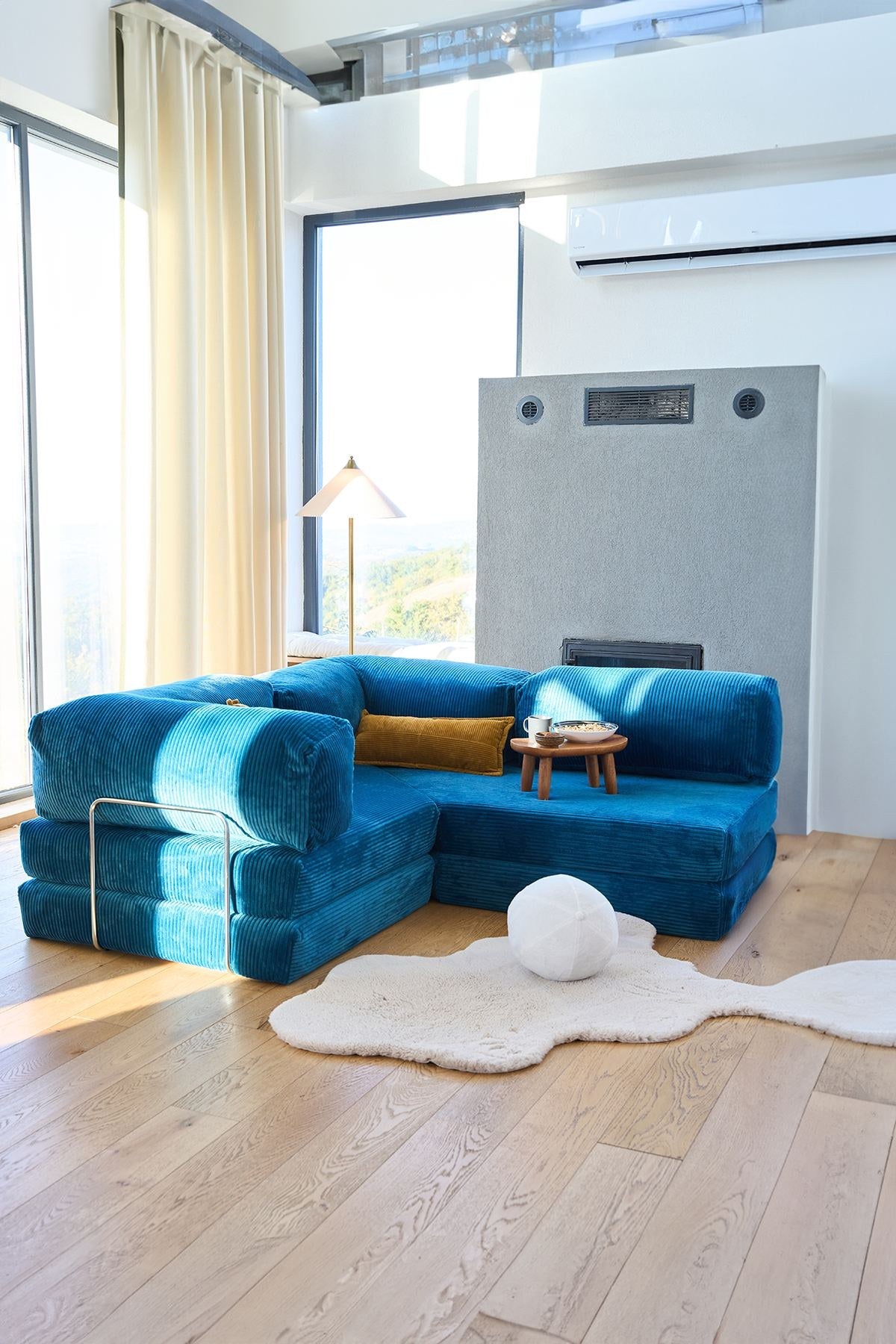 Kanyon Eck-Schlafsofa in Indigo von Hanah Home aus geripptem Cord-Plüschstoff, L-Form mit vier mitgelieferten Kissen.