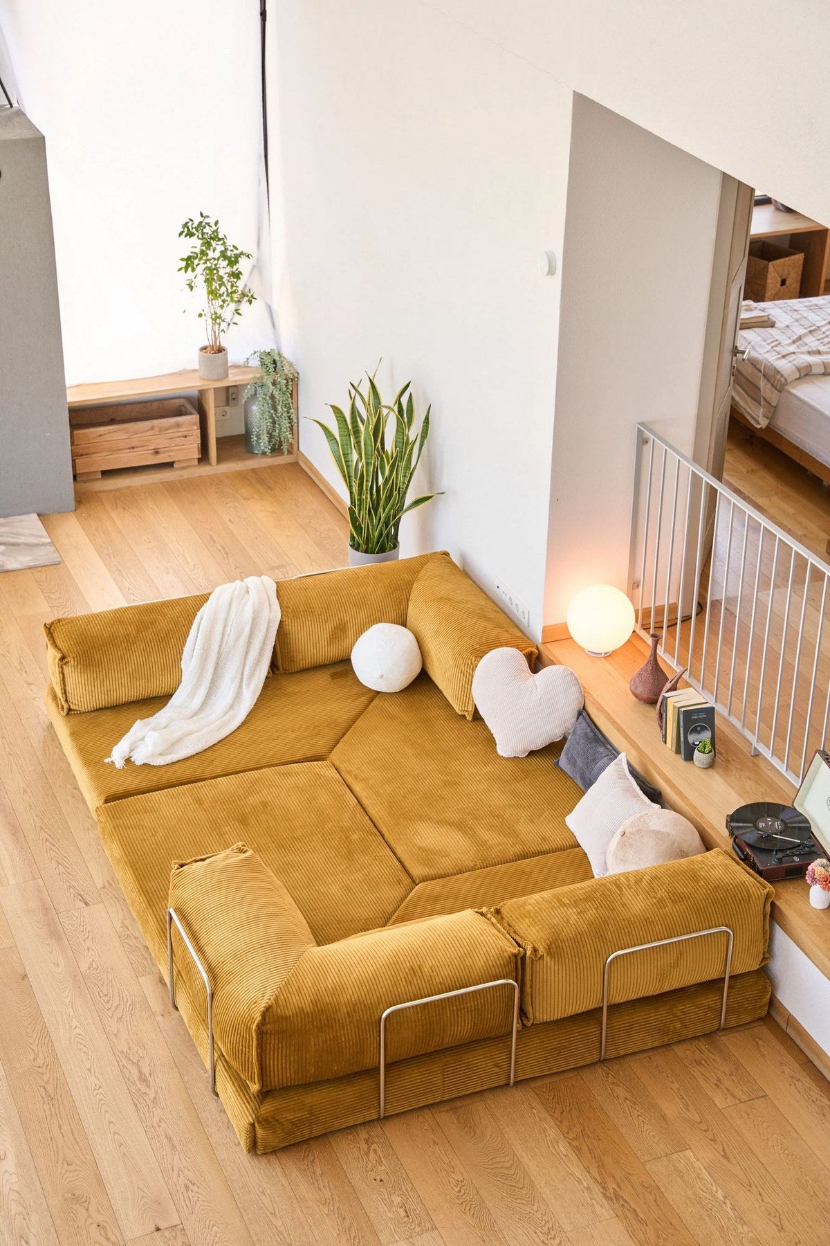 Senfgelbes Eck-Schlafsofa Kanyon von Hanah Home aus geripptem Cord-Plüschstoff mit vier Kissen und rutschfester Sohle.