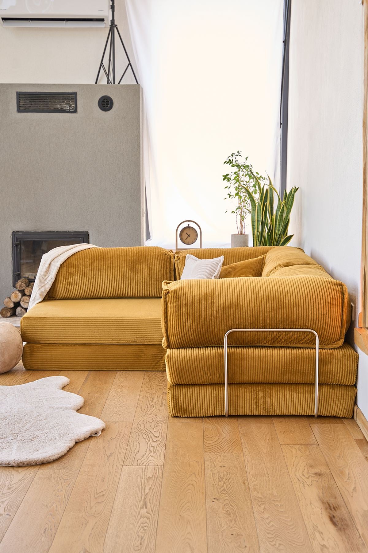 Senfgelbes Eck-Schlafsofa Kanyon von Hanah Home aus geripptem Cord-Plüschstoff mit vier Kissen und rutschfester Sohle.