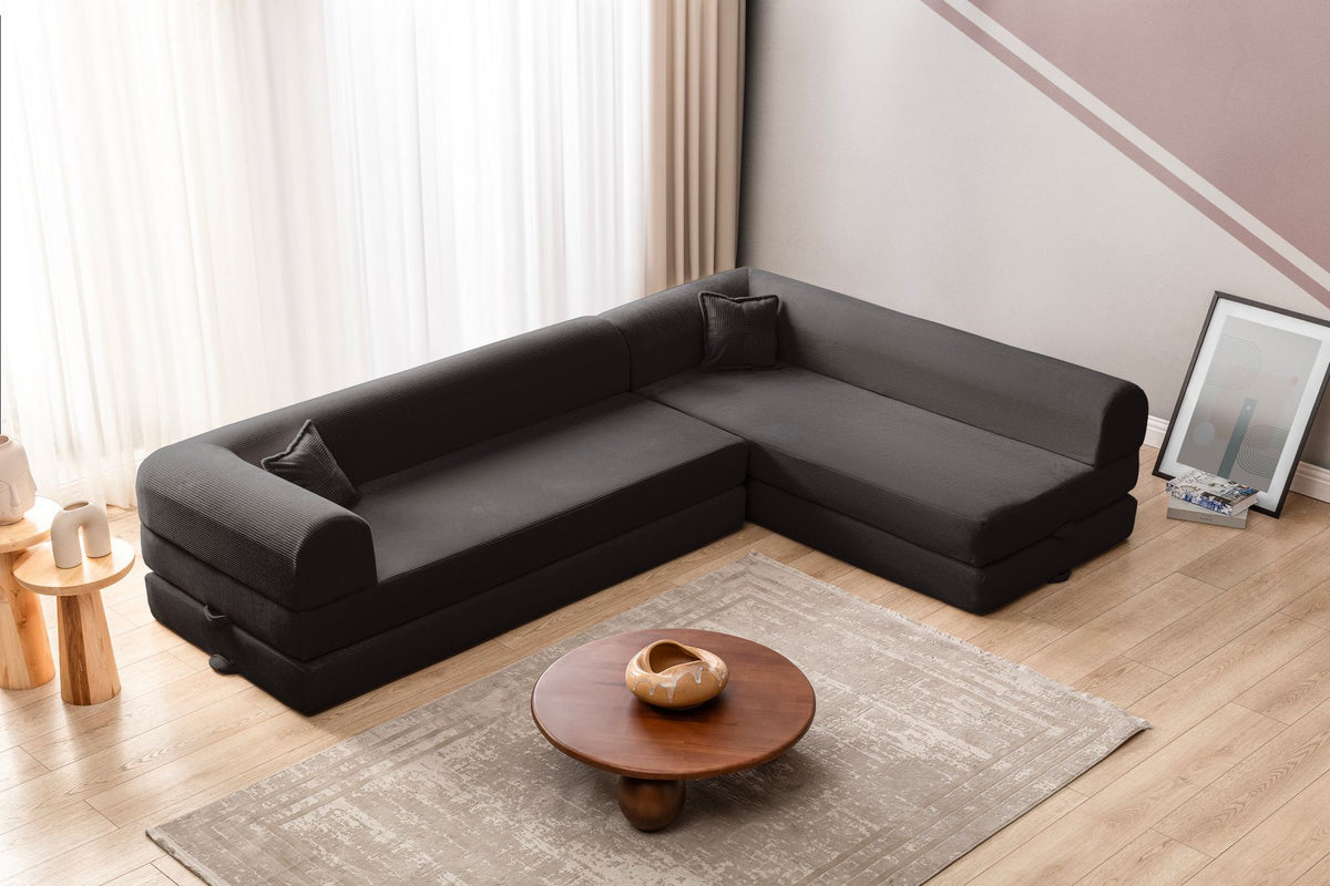Anthrazitfarbenes Ecksofa-Bett aus geripptem Plüschstoff mit vier Kissen, Rollpack-Design und abnehmbarem Bezug, Hanah Home.