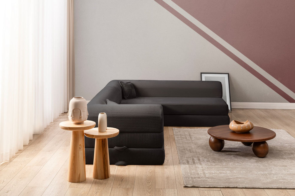 Anthrazitfarbenes Ecksofa-Bett aus geripptem Plüschstoff mit vier Kissen, Rollpack-Design und abnehmbarem Bezug, Hanah Home.