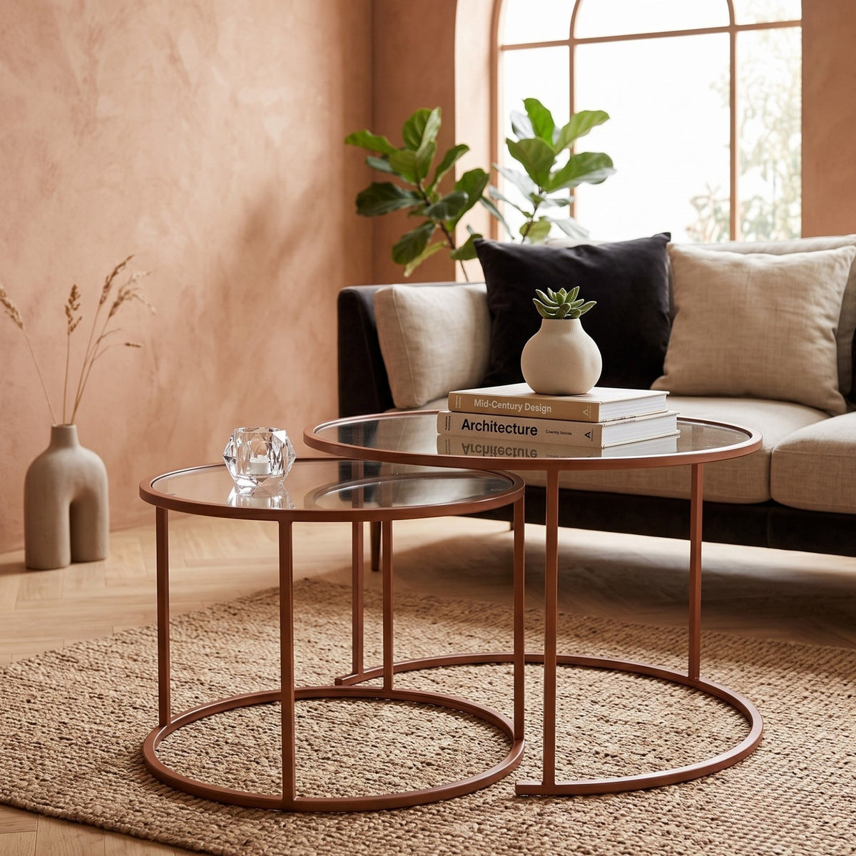 Zwei orangefarbene Couchtische von Hanah Home mit Platten aus gehärtetem Glas und schlankem Metallgestell, unterschiedlich gross, freigestellt.