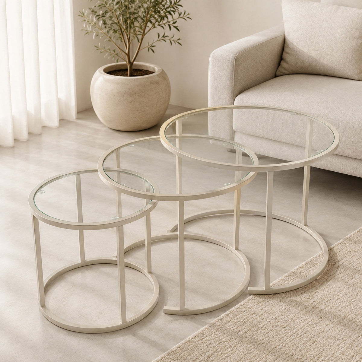 Dreiteiliges Couchtisch-Set von Hanah Home in Beige aus gehärtetem Glas mit schlankem Metallgestell, drei Tische in unterschiedlichen Grössen.