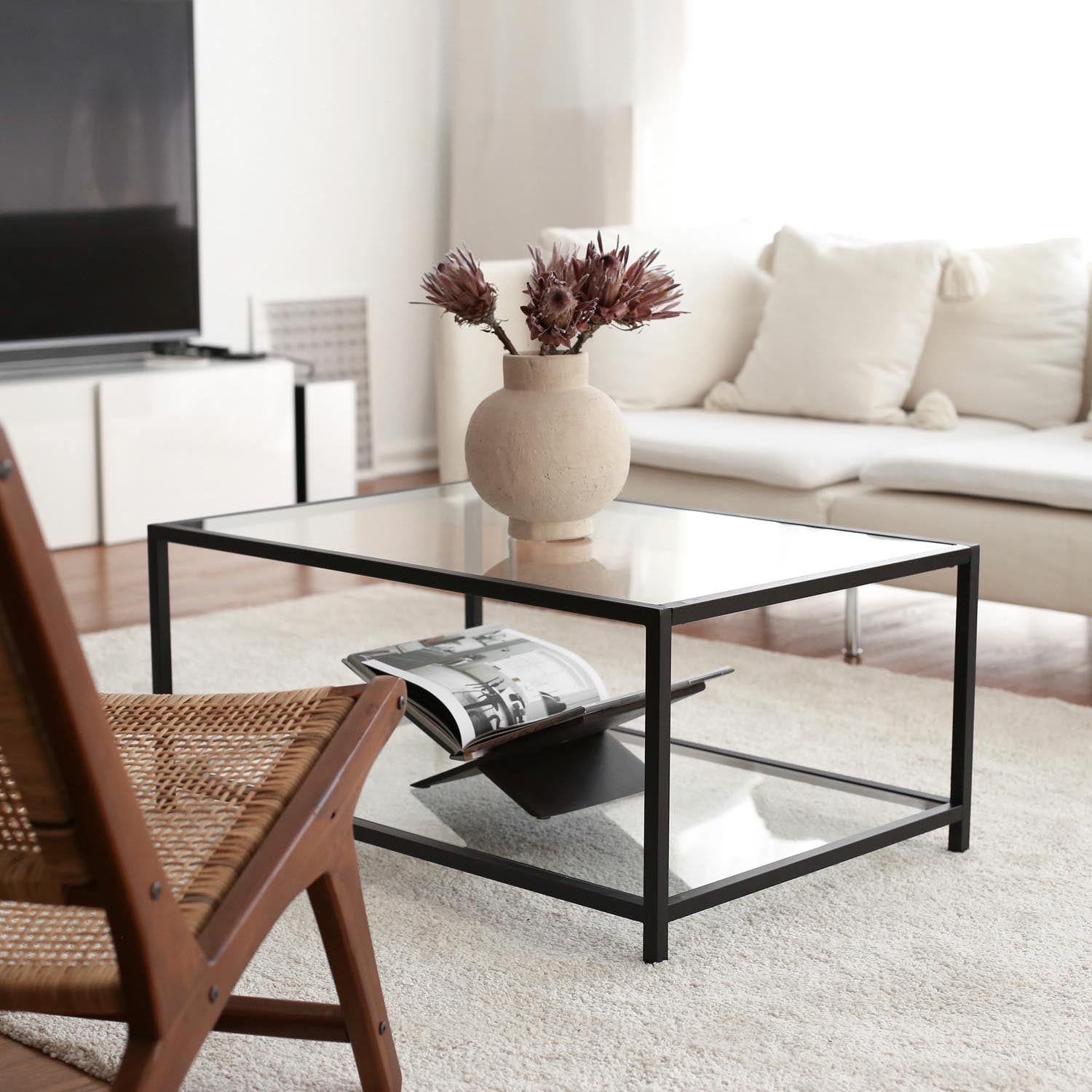 Entdecken Sie den Astro Couchtisch von Hanah Home in Rauch Schwarz – ein stilvolles Möbelstück aus gehärtetem Glas und robustem Metall, das Eleganz und Funktionalität vereint.