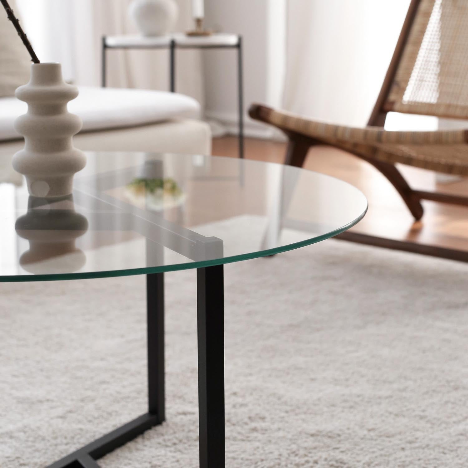 Erleben Sie den Trio Sofatisch von Hanah Home – ein eleganter Couchtisch aus transparentem Glas und schwarzem Metall, der jedem Raum Stil und Raffinesse verleiht.