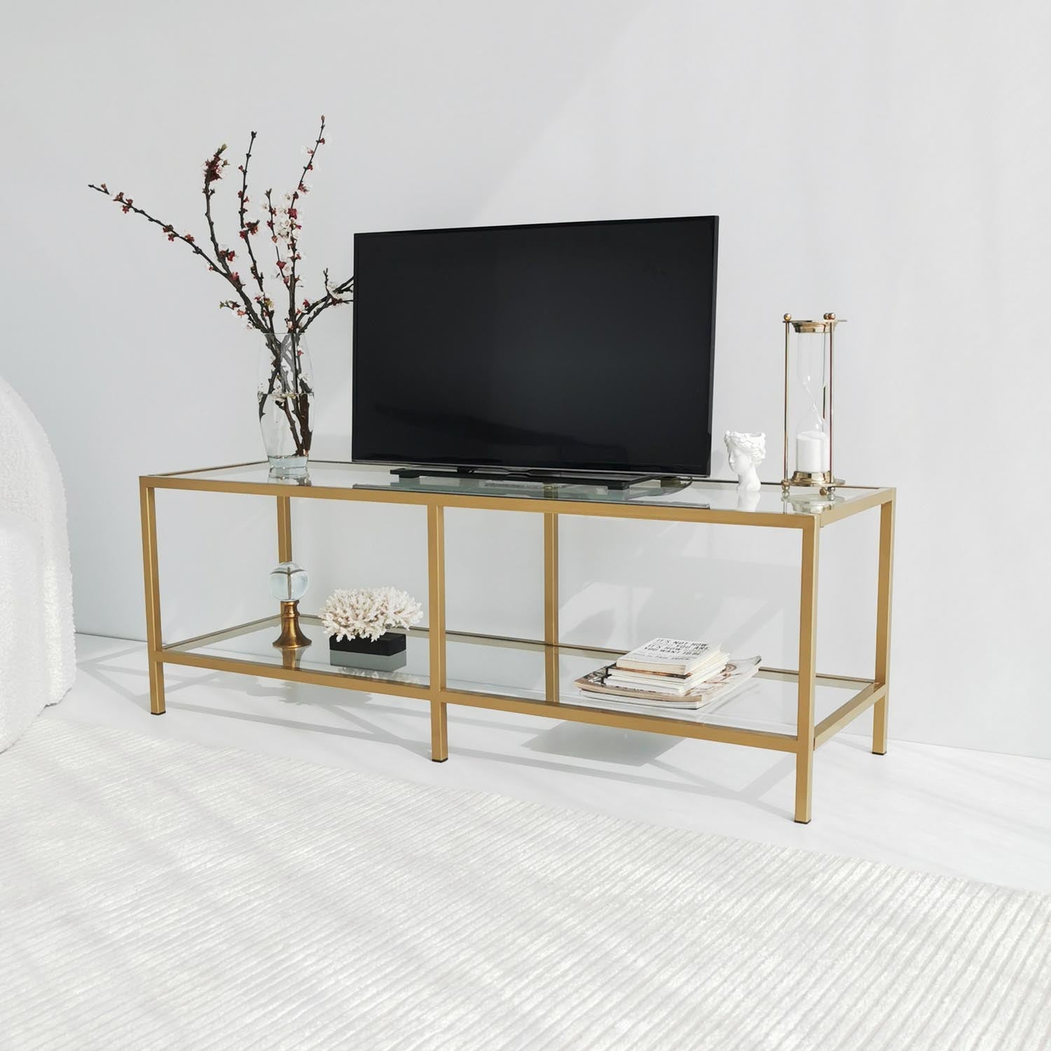 Verleihen Sie Ihrem Wohnzimmer mit dem Basic Gold TV501 Sideboard von Hanah Home einen Hauch von Luxus. Dieser stilvolle TV-Ständer aus robustem Glas und Metall bietet eleganten Stauraum für Ihre Mediengeräte.
