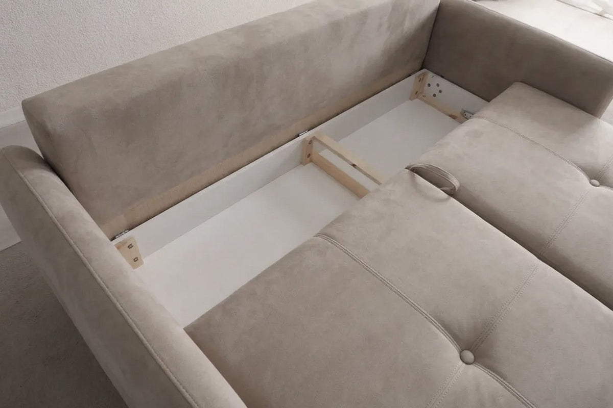 Beige Schlafsofa mit drei Sitzplätzen, Polyesterbezug, Kunststoffbeinen und zwei Kissen, freigestellt vor weissem Hintergrund fotografiert.