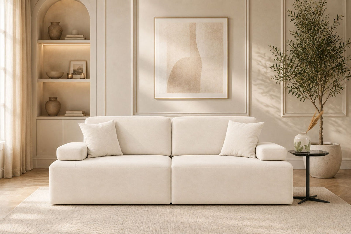 Cremefarbenes 3-Sitzer Sofa aus Polyesterstoff mit Buchenholzgestell, niedrigen Kunststoffbeinen und zwei Kissen.