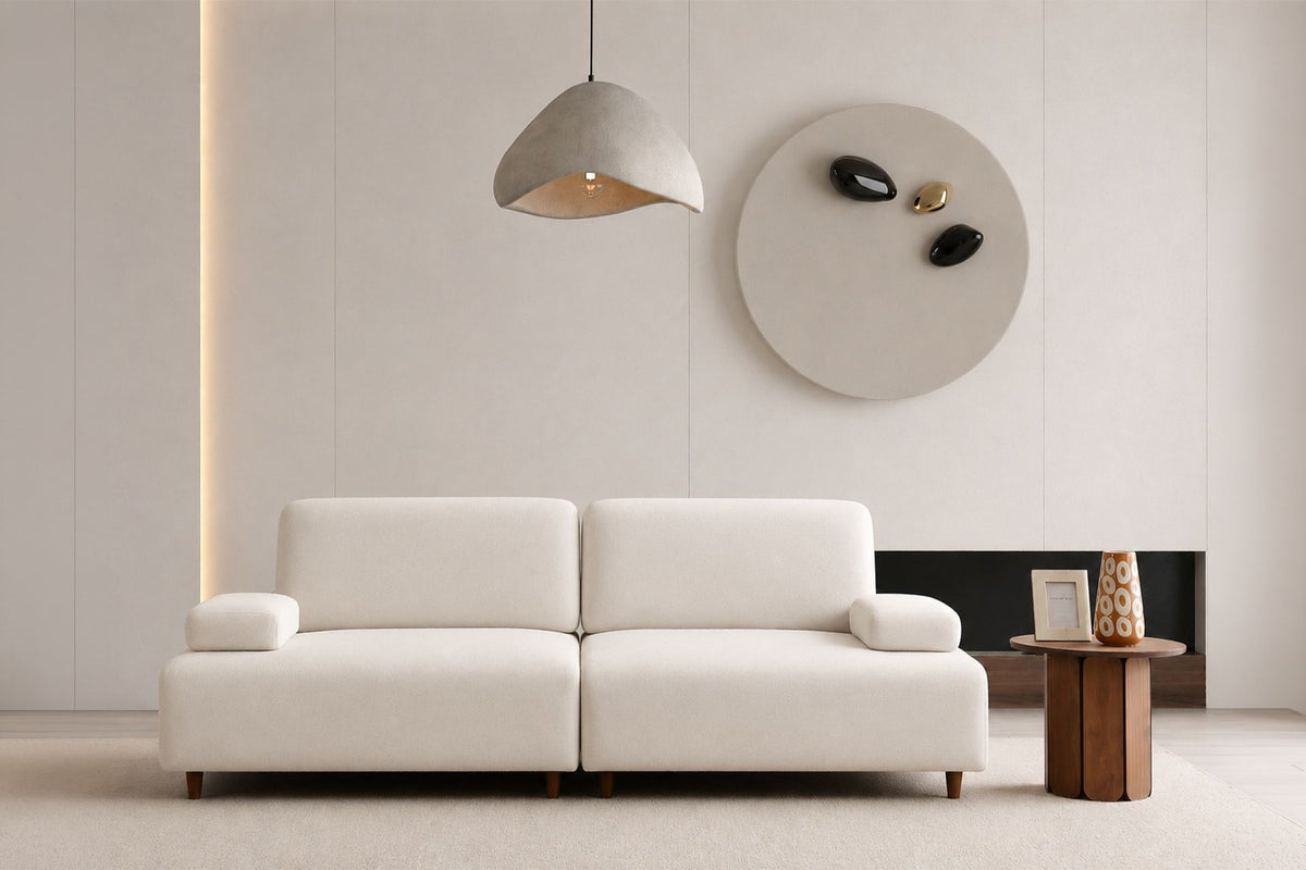 Cremefarbenes 3-Sitzer-Sofa Madlen von Hanah Home mit Polyesterbezug, Kunststoffbeinen und zwei Kissen auf Buchenholzgestell