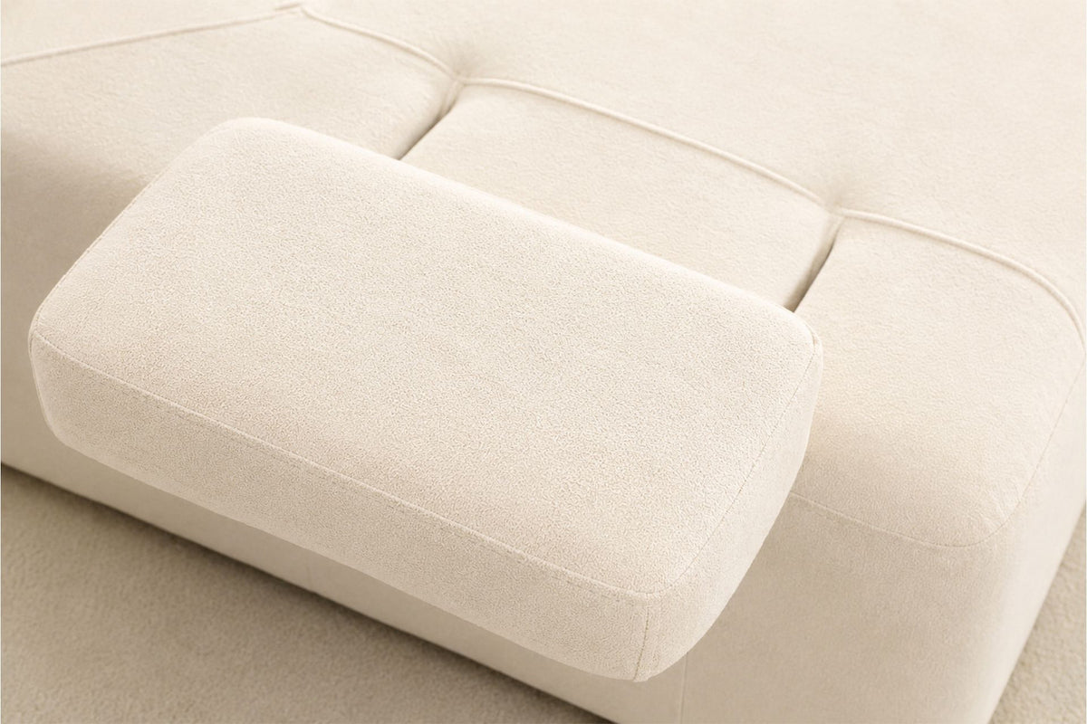 Cremefarbenes Madlen 4-Sitzer Sofa von Hanah Home mit niedrigen Kunststoffbeinen, Polyesterbezug und zwei Kissen auf hellem Untergrund.