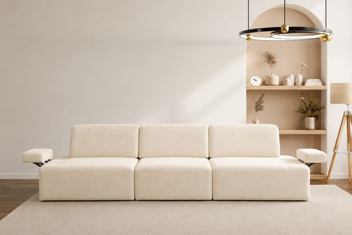 Cremefarbenes Madlen 4-Sitzer Sofa von Hanah Home mit niedrigen Kunststoffbeinen, Polyesterbezug und zwei Kissen auf hellem Untergrund.