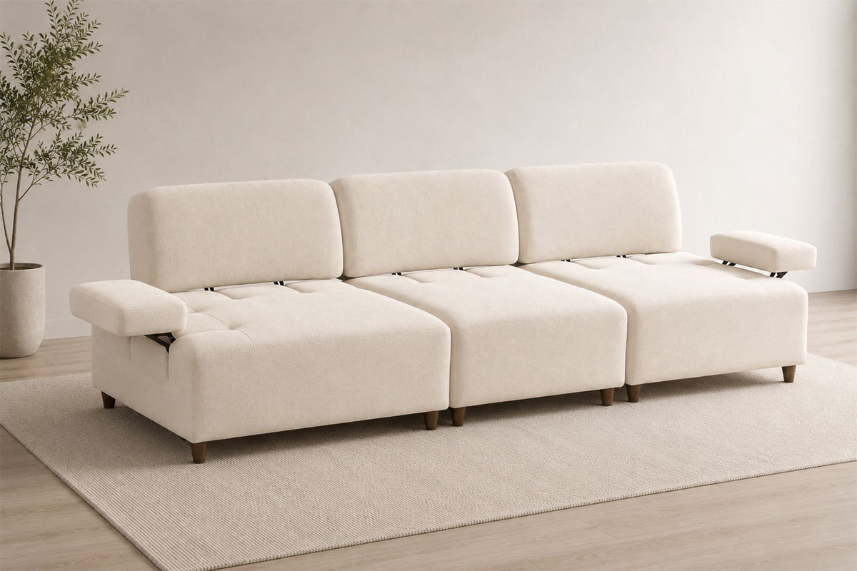 Cremefarbenes 4-Sitzer-Sofa mit hohen Kunststoffbeinen, Polyesterbezug, Buchenholzgestell und zwei losen Kissen auf hellem Hintergrund.