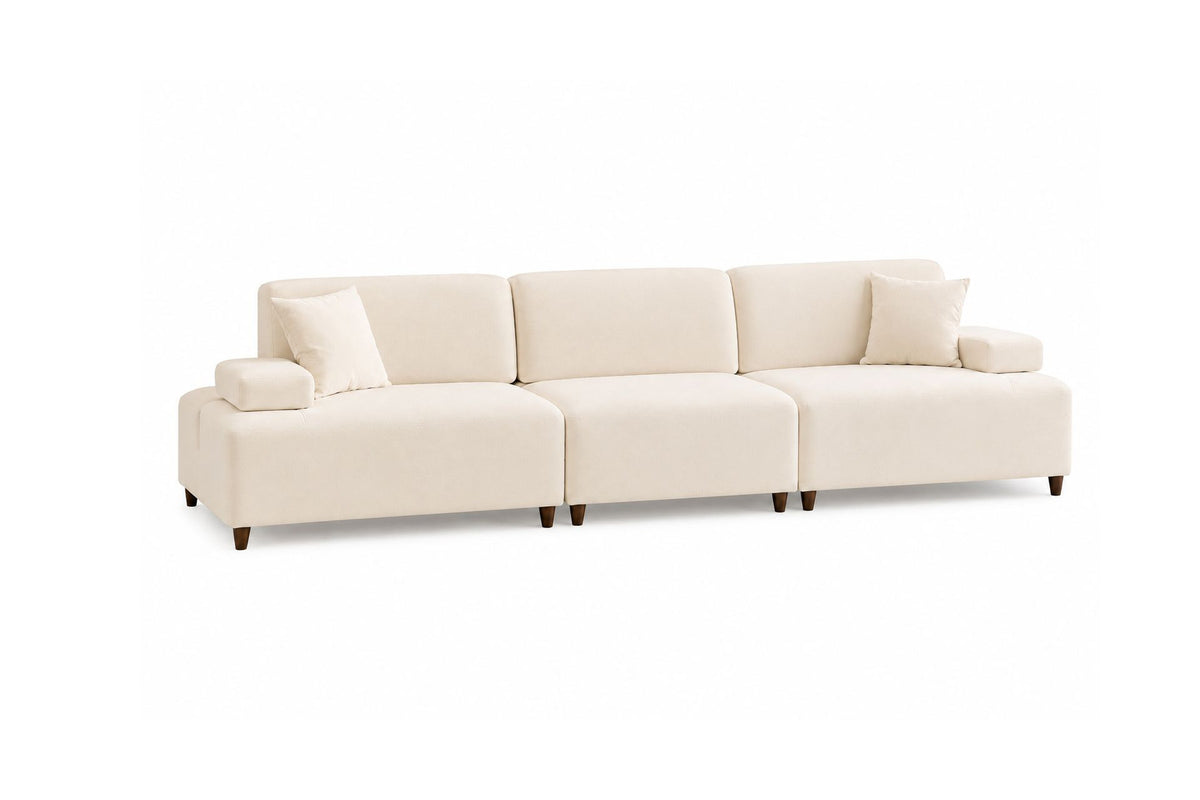 Cremefarbenes 4-Sitzer-Sofa mit hohen Kunststoffbeinen, Polyesterbezug, Buchenholzgestell und zwei losen Kissen auf hellem Hintergrund.
