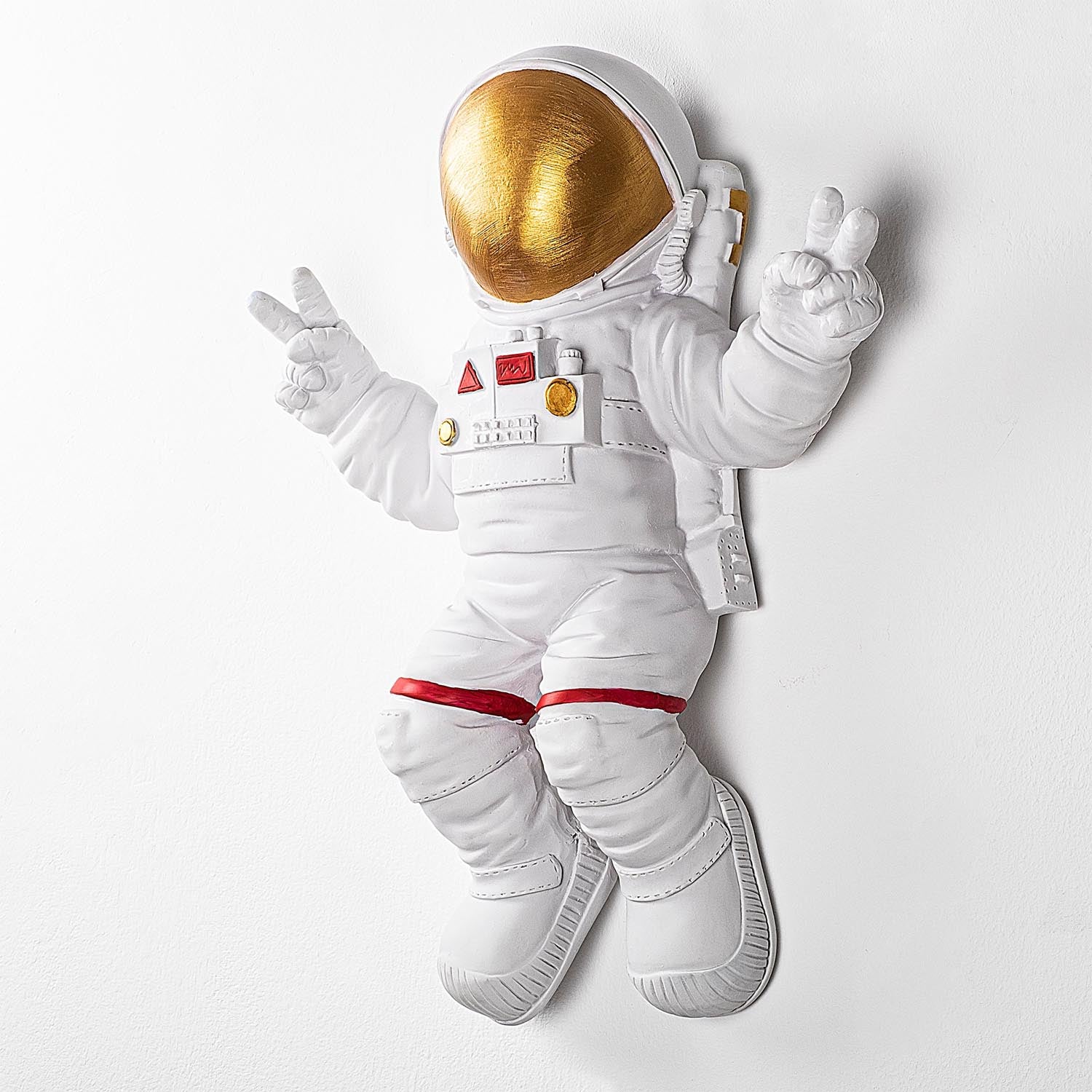 Verleihen Sie Ihrem Raum mit der stilvollen Wanddeko "Peace Sign Astronaut" von Wallity in Weiß und Gold einen Hauch von Luxus und Kreativität!
