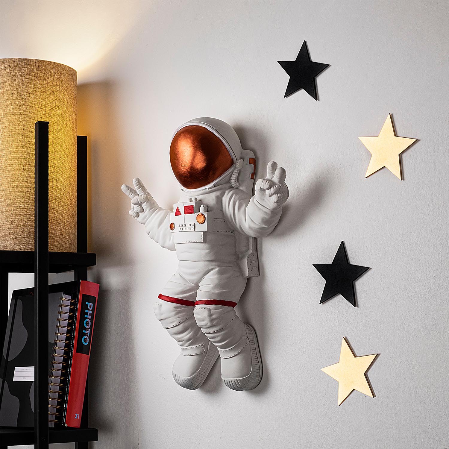 Verleihen Sie Ihrem Raum mit der eleganten Peace Sign Astronaut Wanddeko in Weiß und Bronze von Wallity einen Hauch von Stil und Raffinesse.