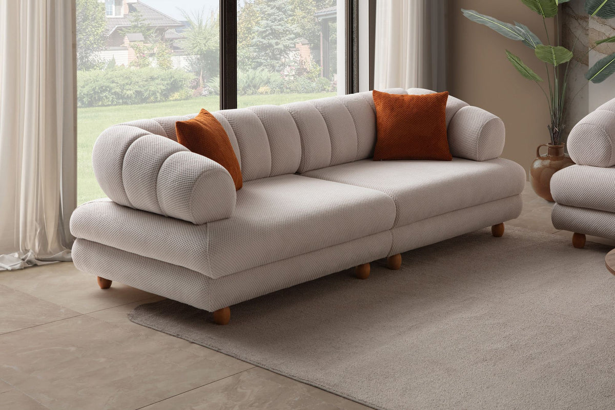 Beiges 3-Sitzer Sofa Gloria von Hanah Home mit Polyesterbezug, Holzbeinen und zwei Kissen, Frontalansicht auf hellem Hintergrund.
