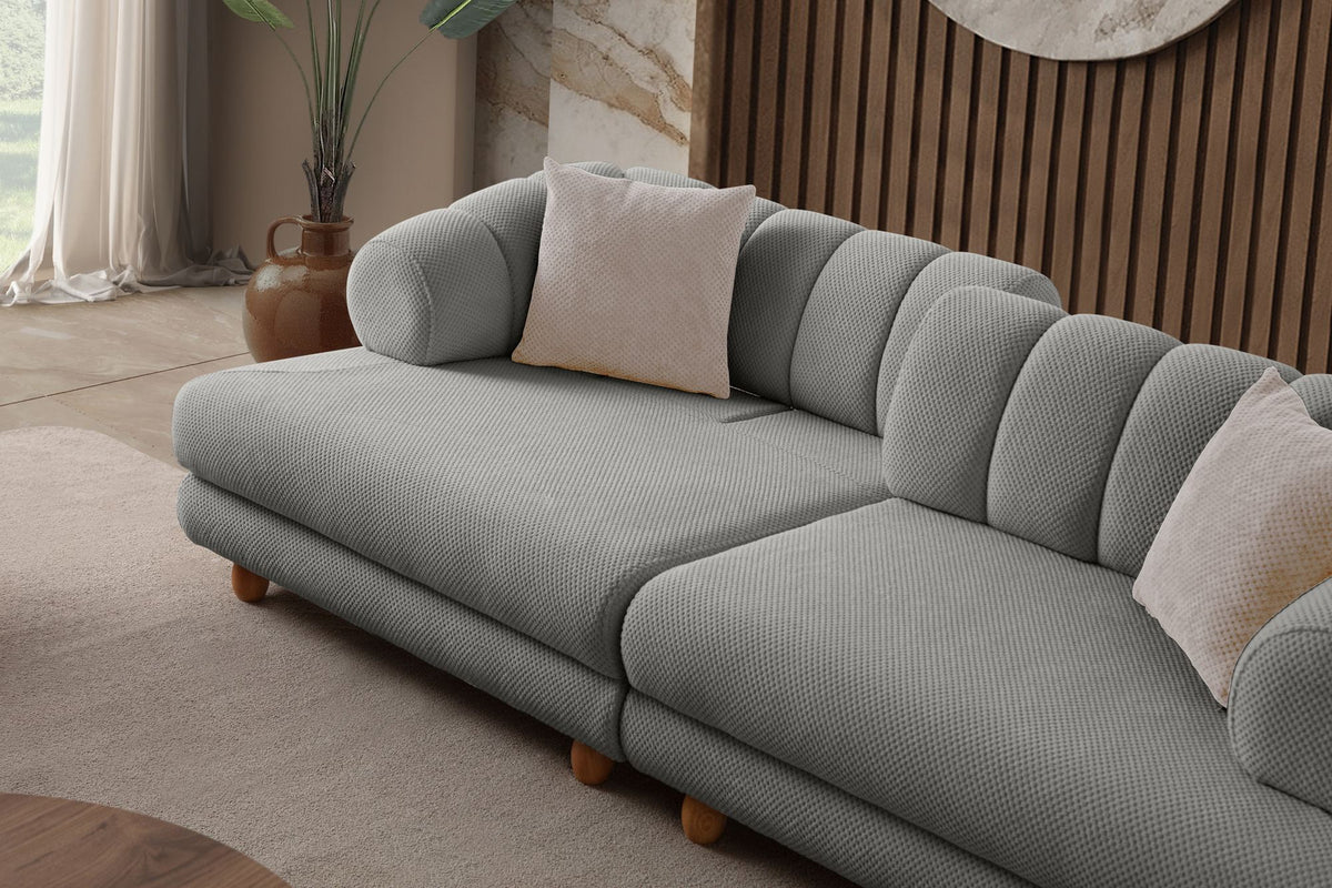 Graues 3-Sitzer Sofa Gloria von Hanah Home mit Polyesterbezug in Tuna-Struktur, Holzbeinen und zwei losen Kissen auf hellem Untergrund.