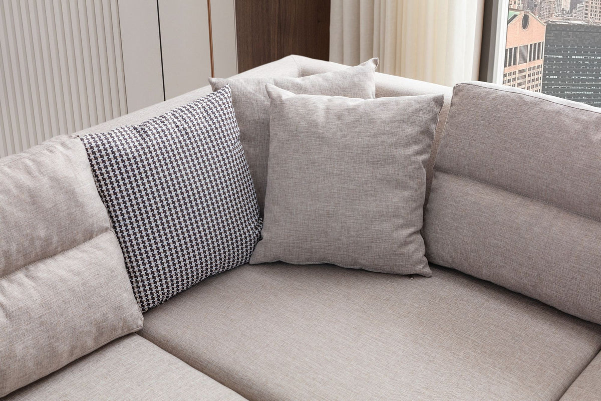 Cremefarbenes Eckschlafsofa T-Loft von Hanah Home mit Leinenstruktur-Stoffbezug, Kunststoffbeinen und acht dekorativen Kissen.