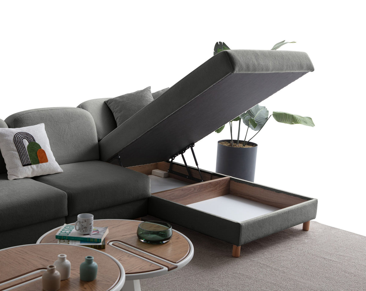 Anthrazitfarbenes Eck-Schlafsofa mit Coco-Boucle-Stoffbezug, Holzbeinen und rechter Truhe, fotografiert freistehend im Raum.