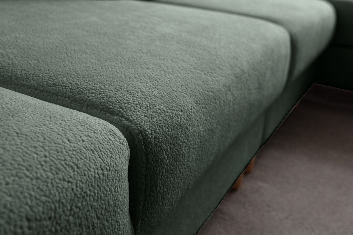 Grünes Eck-Schlafsofa Aries von Hanah Home mit Coco-Boucle-Stoff, Holzbeinen und Aufbewahrungstruhe, rechts ausgerichtet.