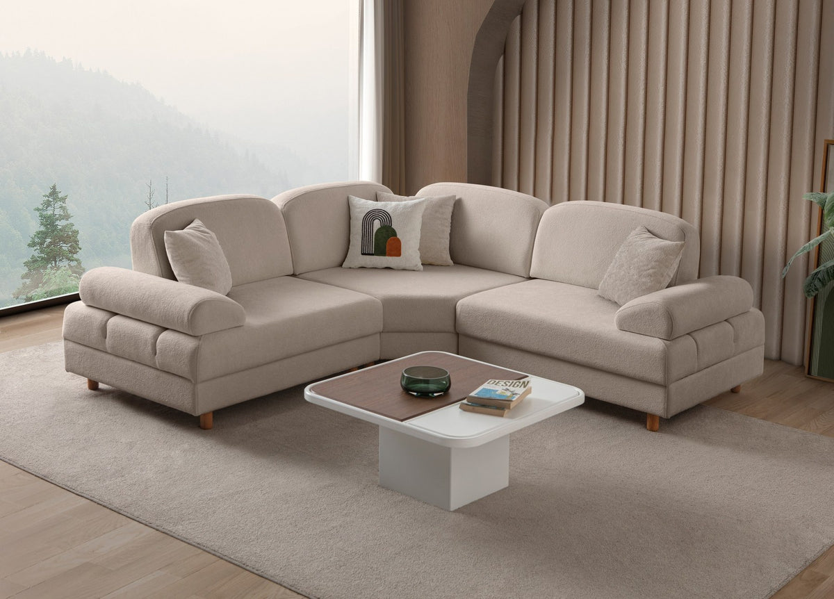 Eckschlafsofa Aries Modular S in Milchkaffee mit Coco-Boucle-Stoff, Holzbeinen und vier Kissen, fotografiert im Wohnraum.