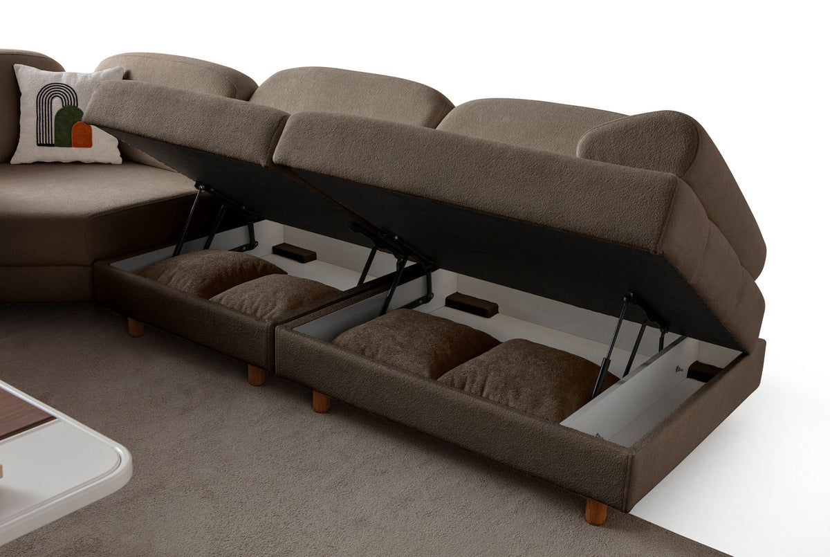 Braunes Eck-Schlafsofa Aries Modular M mit Coco-Boucle-Stoffbezug, Holzbeinen und sichtbarer Truhe, im Wohnzimmer aufgestellt.
