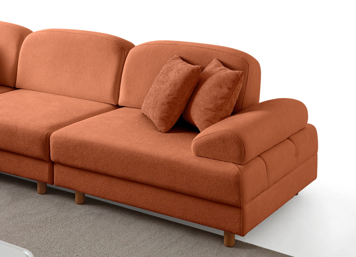 Orangefarbenes Eck-Schlafsofa Aries Modular M mit Coco-Boucle-Stoff, Holzbeinen und sechs Kissen, aufgenommen in einem Wohnraum.