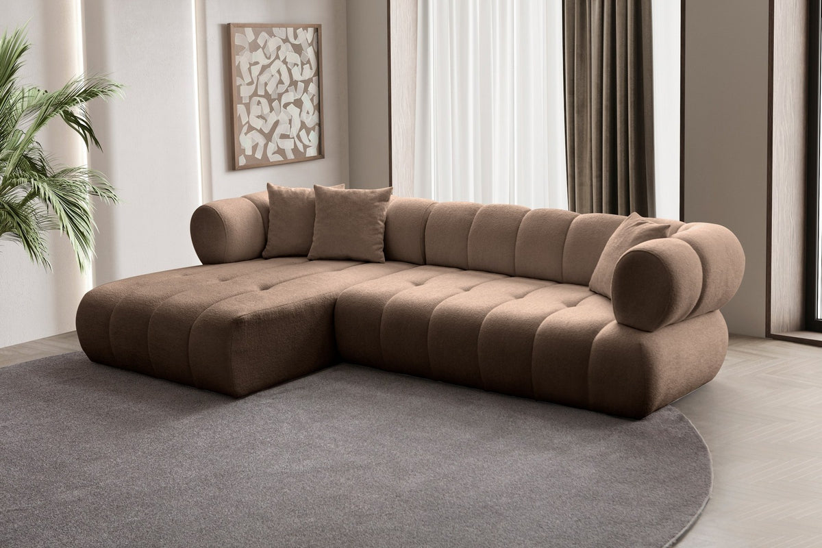 Ecksofa Petra links in Nerz-Farbton mit Boucle-Stoff-Bezug, Kunststofffüssen und drei losen Kissen, Ansicht von vorne.