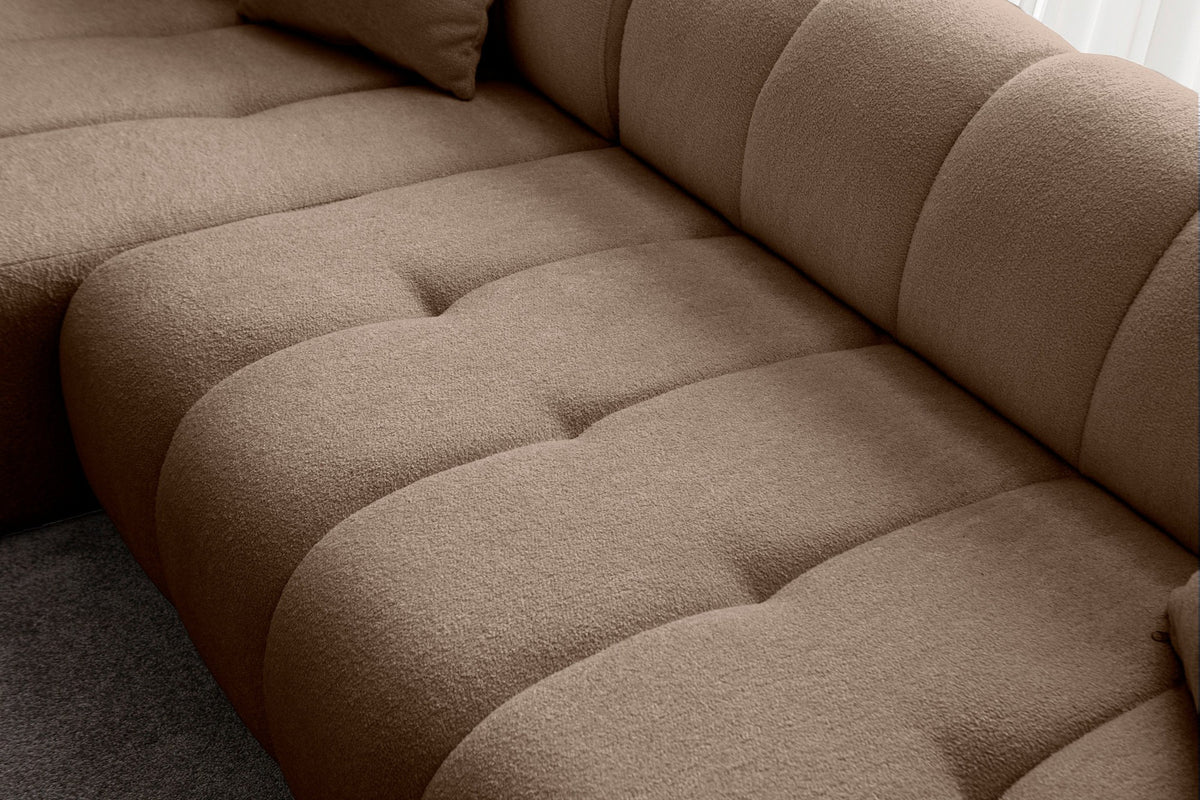 Ecksofa Petra links in Nerz-Farbton mit Boucle-Stoff-Bezug, Kunststofffüssen und drei losen Kissen, Ansicht von vorne.