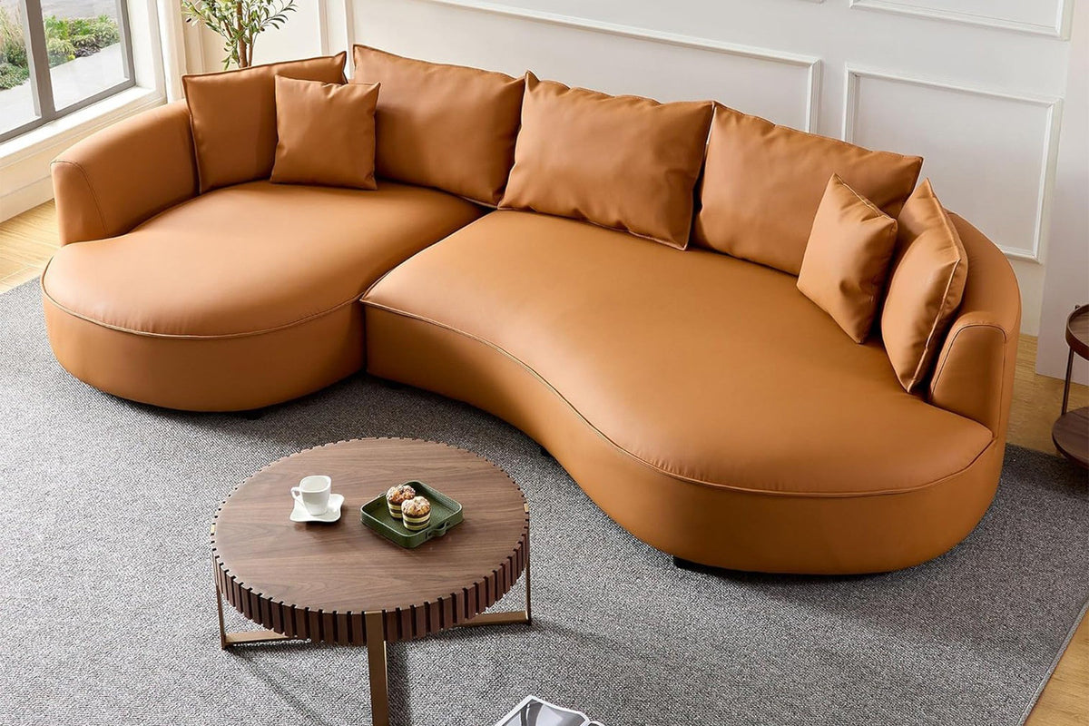 Orangefarbenes Ecksofa Venedik links von Hanah Home mit glattem Kunstlederbezug, Kunststoffbeinen und sieben mitgelieferten Kissen.