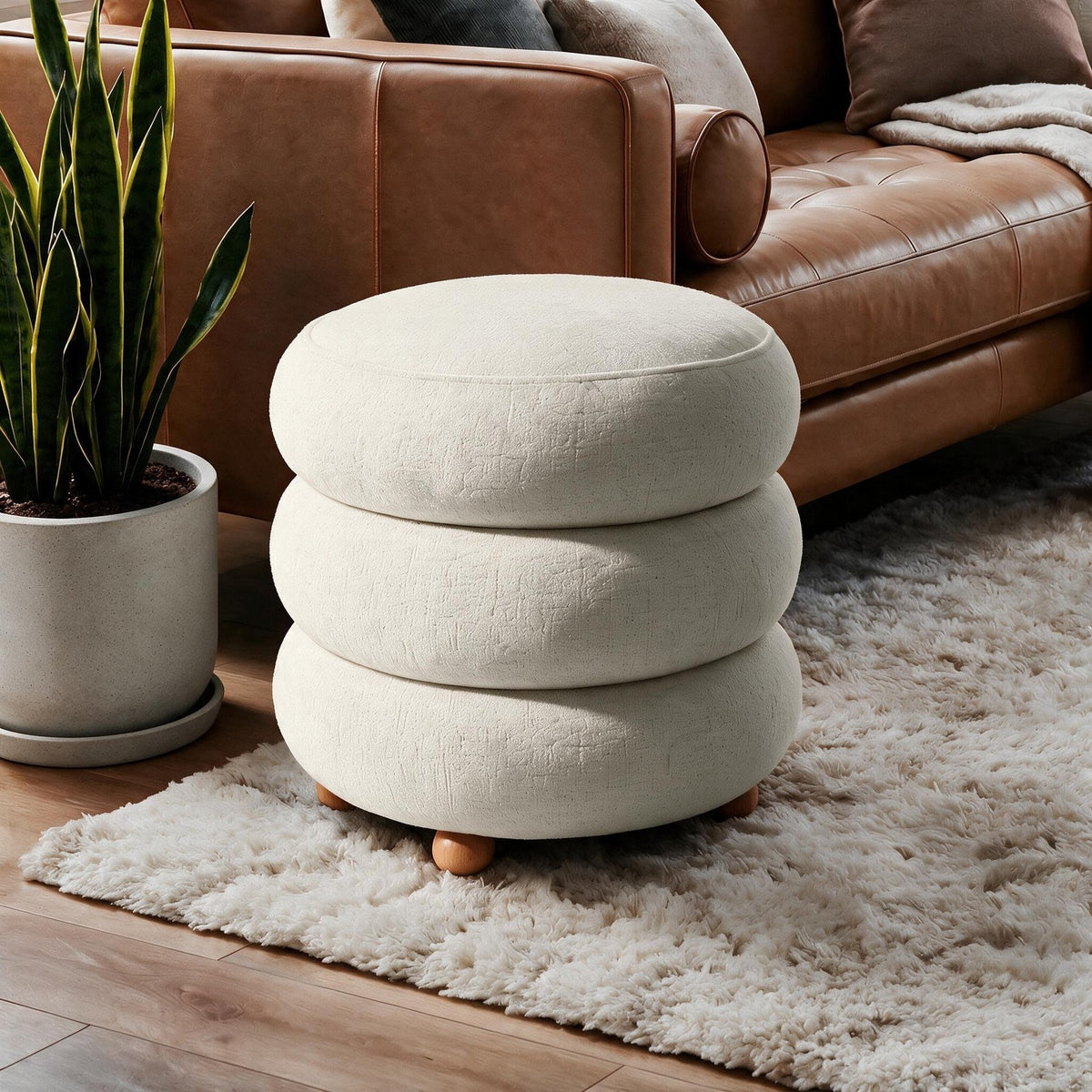 Runder Pouf in Off-White von Hanah Home mit gestricktem Polyesterbezug, Holz-Kugelfüssen und sichtbarem Stauraumfach im Innenraum.
