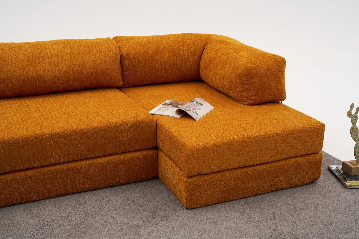 Oranges Ecksofa Comfort von Atelier Del Sofa mit Chenille-Bezug, L-Form und ausklappbarer Liegefläche, fotografiert in Studioumgebung.