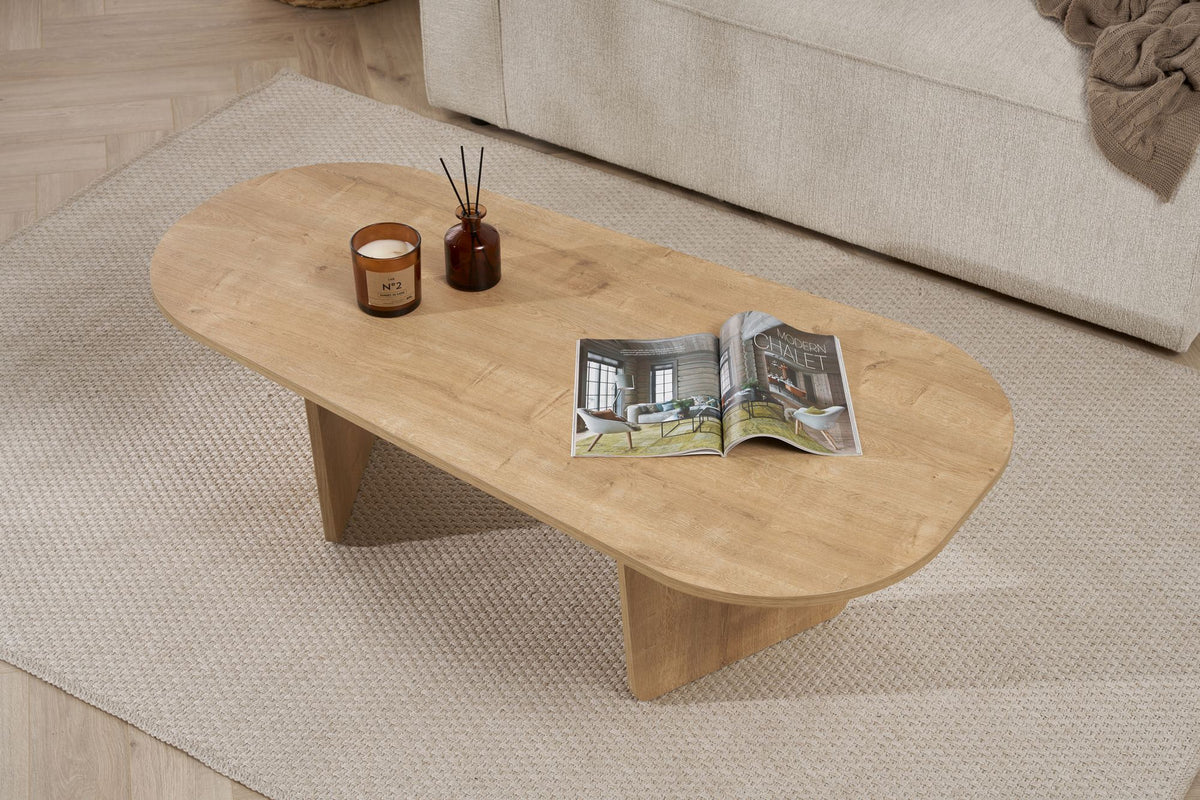 Couchtisch Ovalis von Nordure in Eiche-Optik, Tischplatte aus melaminbeschichteter Spanplatte, Masse 130x65x40 cm, freistehend im Raum.