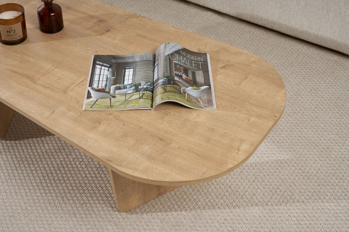 Couchtisch Ovalis von Nordure in Eiche-Optik, Tischplatte aus melaminbeschichteter Spanplatte, Masse 130x65x40 cm, freistehend im Raum.