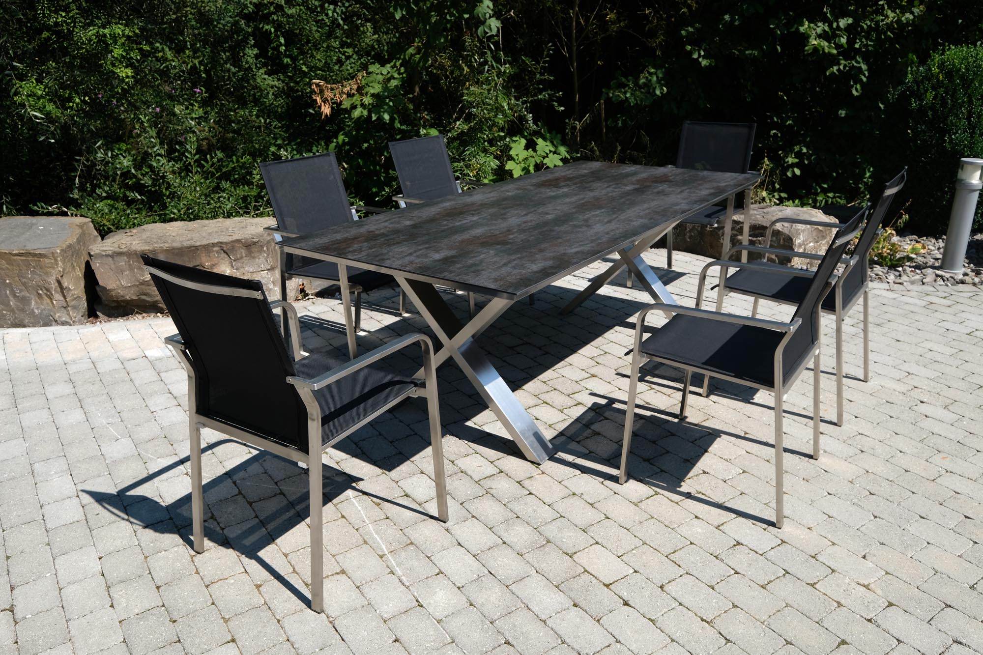 Moderner Gartentisch Monaco in Grau, 210x100 cm, mit robuster Edelstahl X-Form und attraktiver Oberflächenstruktur für elegante Außenbereiche.