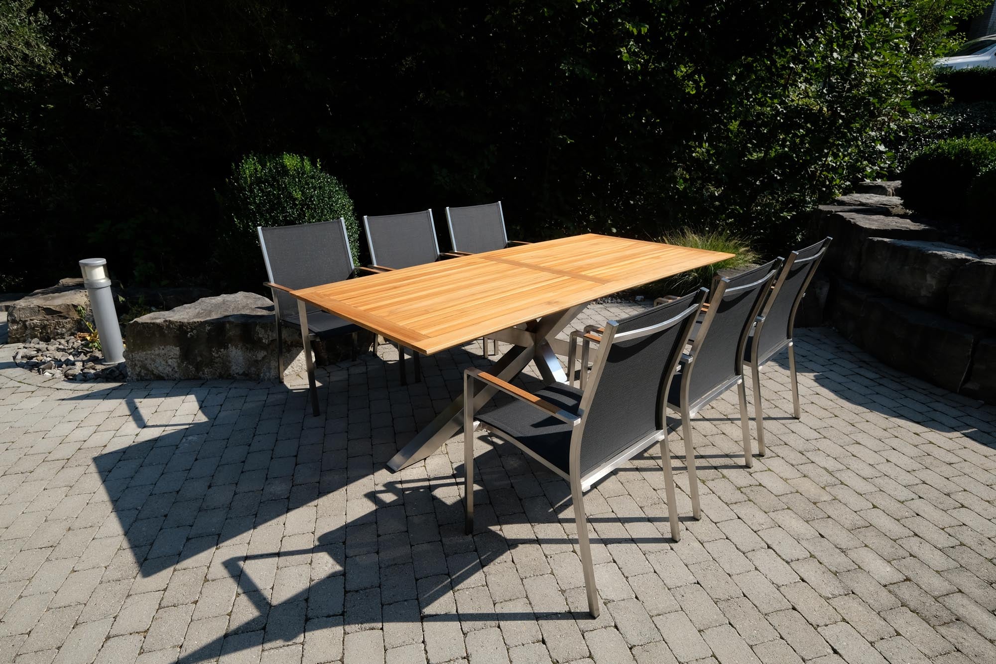 Moderner Gartentisch Monaco mit robusten XX-Füßen und edler Teakplatte, perfekt für gemütliche Stunden im Freien.