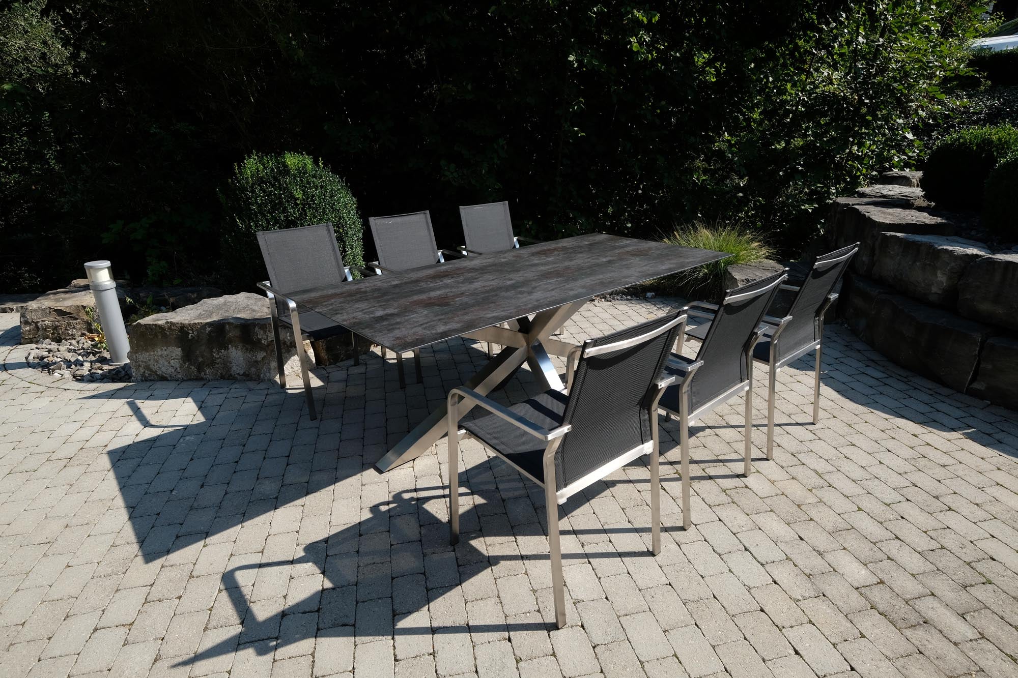 Eleganter Gartentisch Monaco mit XX-Fuß aus Edelstahl, 210x100 cm, in stilvollem Grau mit strukturierter Oberfläche, ideal für den Außenbereich.