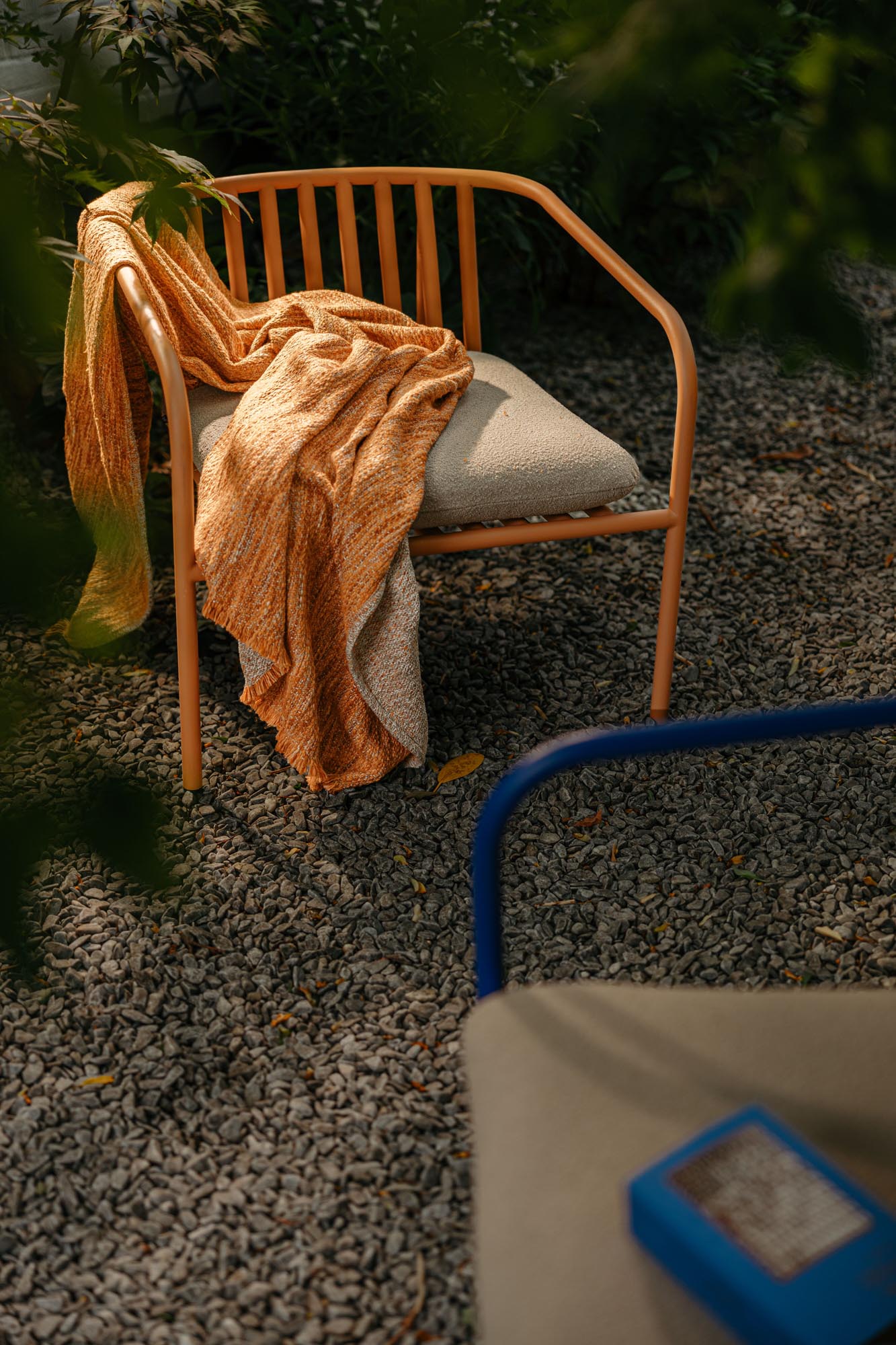Eleganter Gartensessel Bendt mit komfortablen Armlehnen in sanften Pfirsich- und Beigetönen, perfekt für entspannte Stunden im Freien.