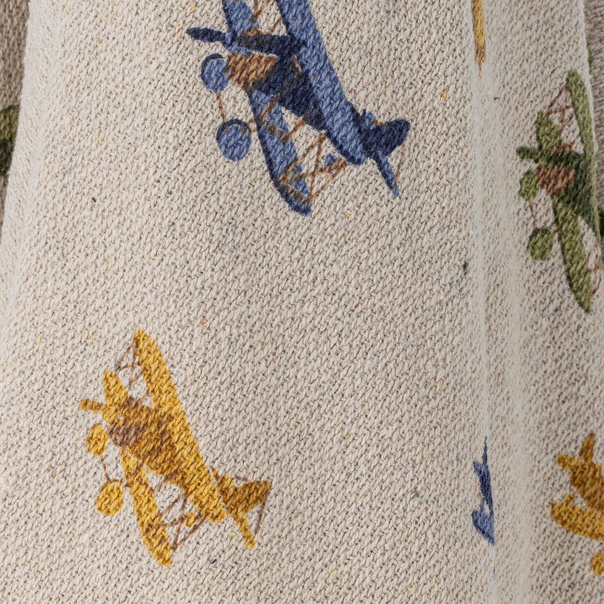 Weisse Wolldecke der Serie Plane von Bloomingville Mini aus Baumwolle, Polyester und Viskose, bedruckt mit Flugzeug- und Wolkenmotiv, blaue Quasten an den Ecken.