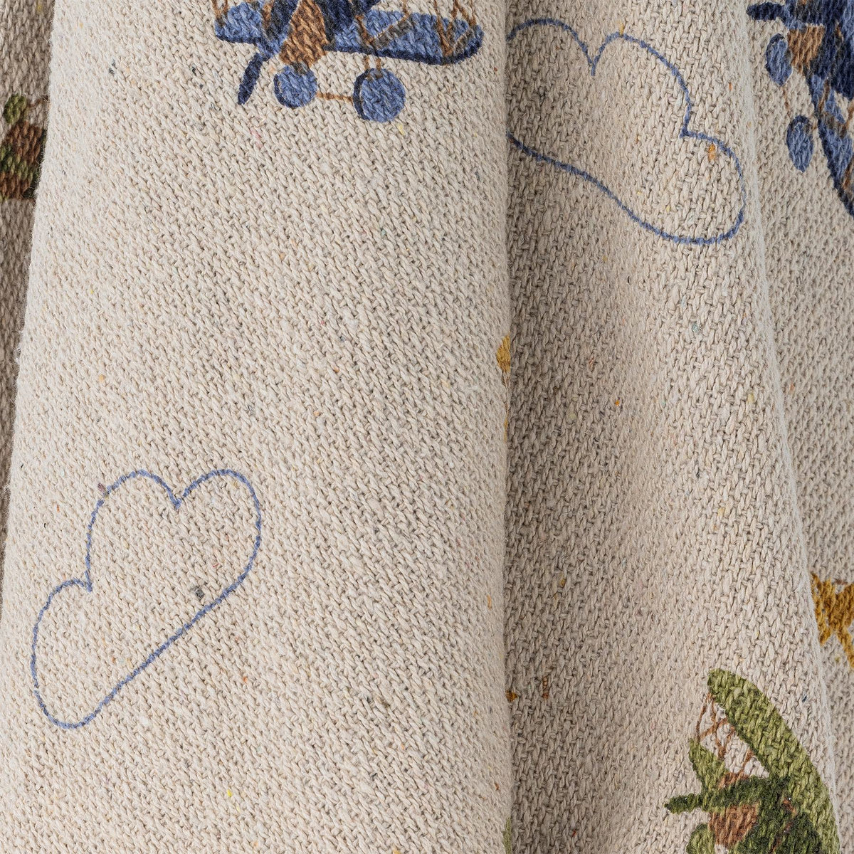Weisse Wolldecke der Serie Plane von Bloomingville Mini aus Baumwolle, Polyester und Viskose, bedruckt mit Flugzeug- und Wolkenmotiv, blaue Quasten an den Ecken.