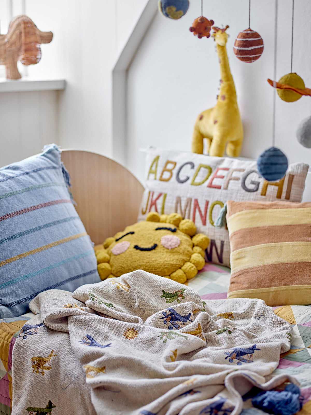 Weisse Wolldecke der Serie Plane von Bloomingville Mini aus Baumwolle, Polyester und Viskose, bedruckt mit Flugzeug- und Wolkenmotiv, blaue Quasten an den Ecken.