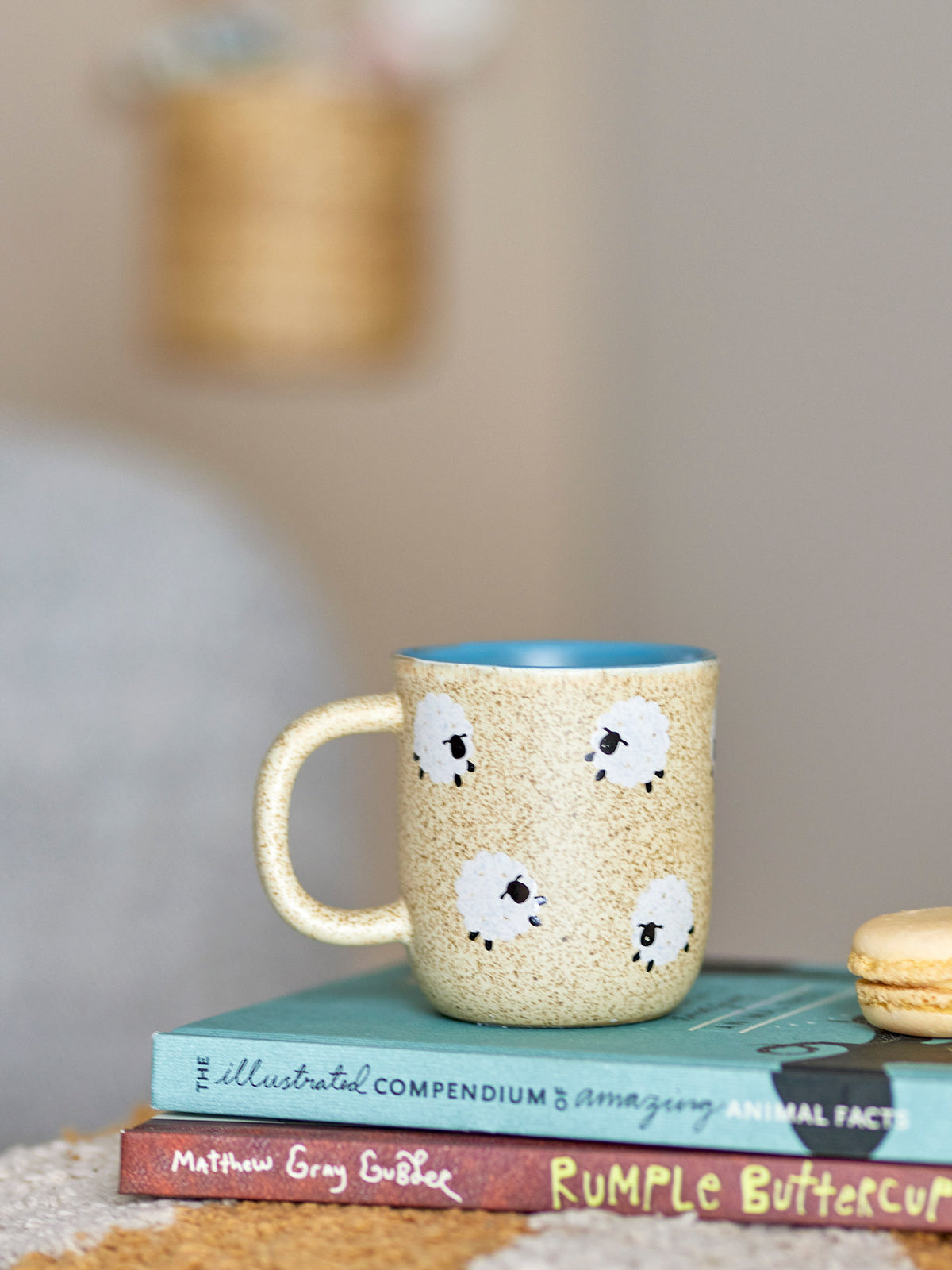 Beige Tasse aus Steingut mit gesprenkelter Oberfläche und weissen Schafmotiven, Serie Dolly von Bloomingville Mini, rund mit Henkel.
