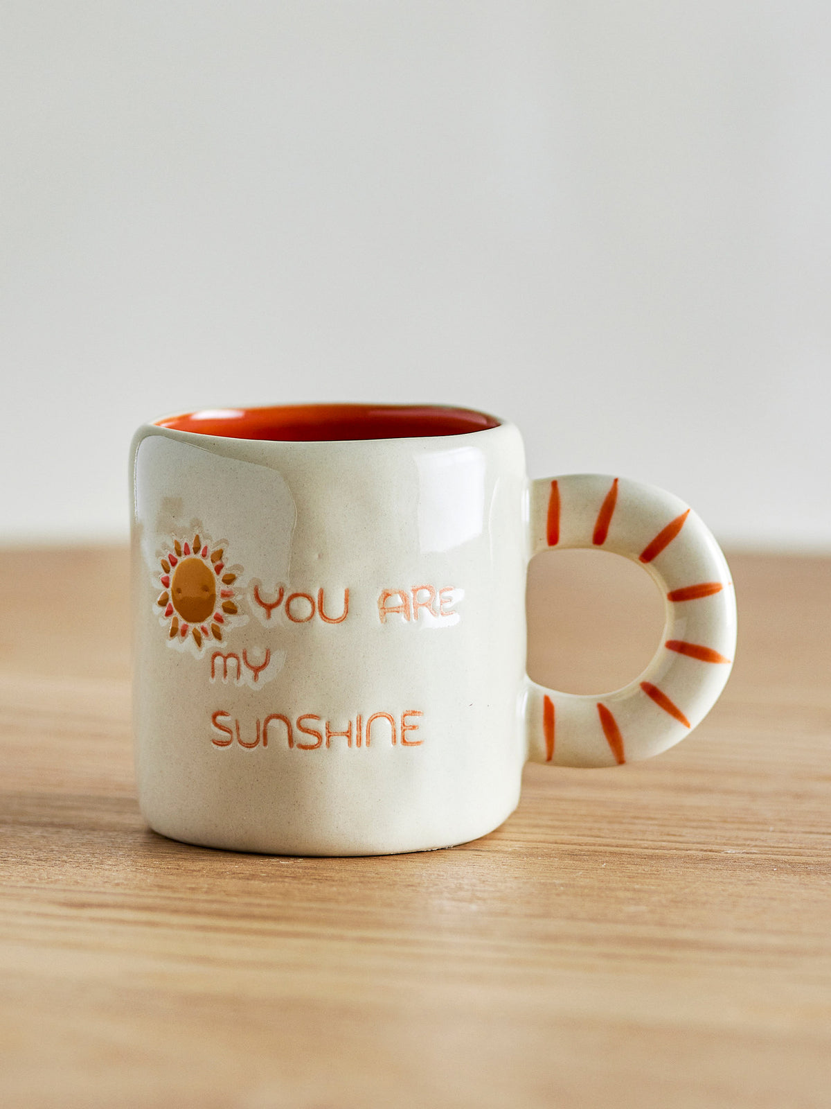 Weisse Cloudy Tasse aus Steingut mit Regenbogen als Griff und Schriftzug
