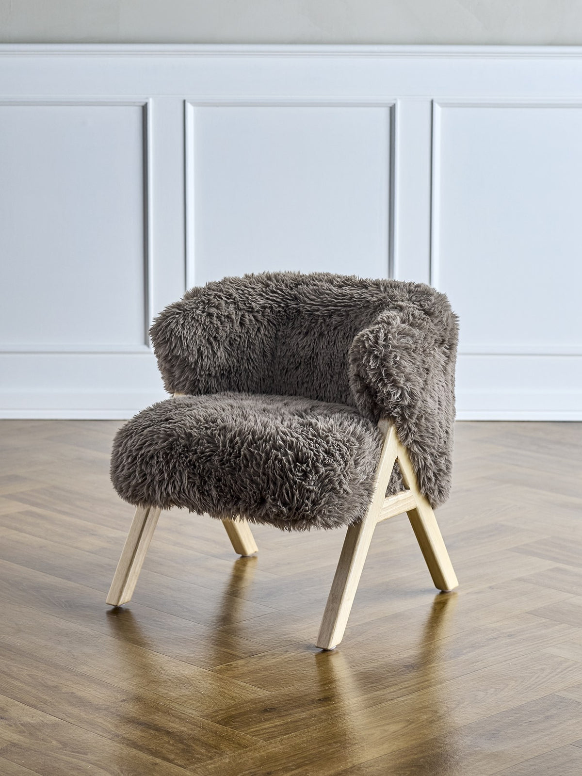 Camino Loungesessel von Bloomingville Mini in Braun mit gepolstertem Hochflor-Fleece-Bezug, abgerundeter Form und hellen Holzbeinen.