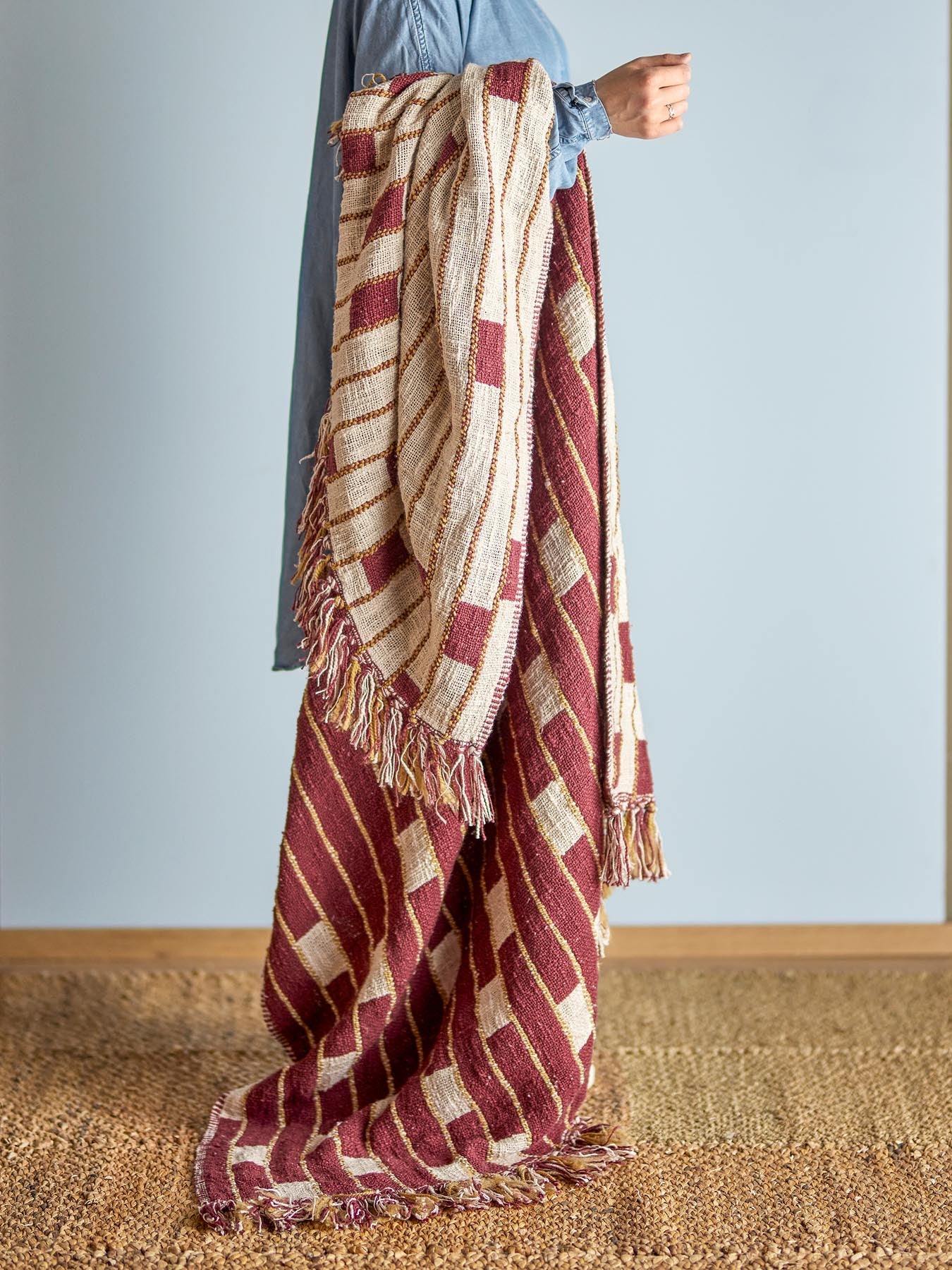 Entdecken Sie die stilvolle Cang Decke von Bloomingville in warmen Rot- und Beigetönen. Perfekt für Gemütlichkeit und Eleganz in jedem Raum.