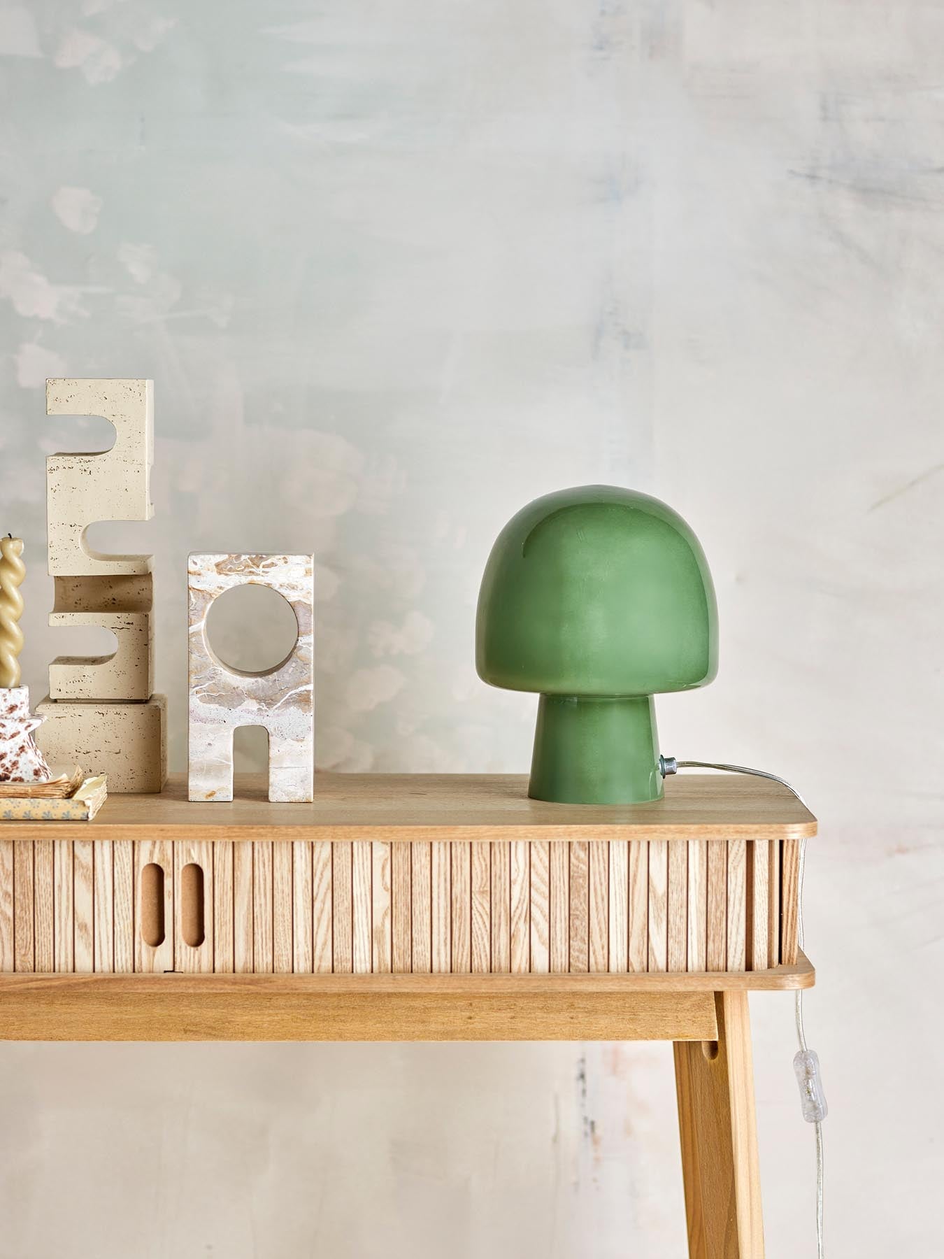 Die Paddy Tischlampe von Bloomingville vereint modernes Design und natürliche Eleganz. Ihr grünes Glas und die pilzartige Form schaffen eine gemütliche Atmosphäre.